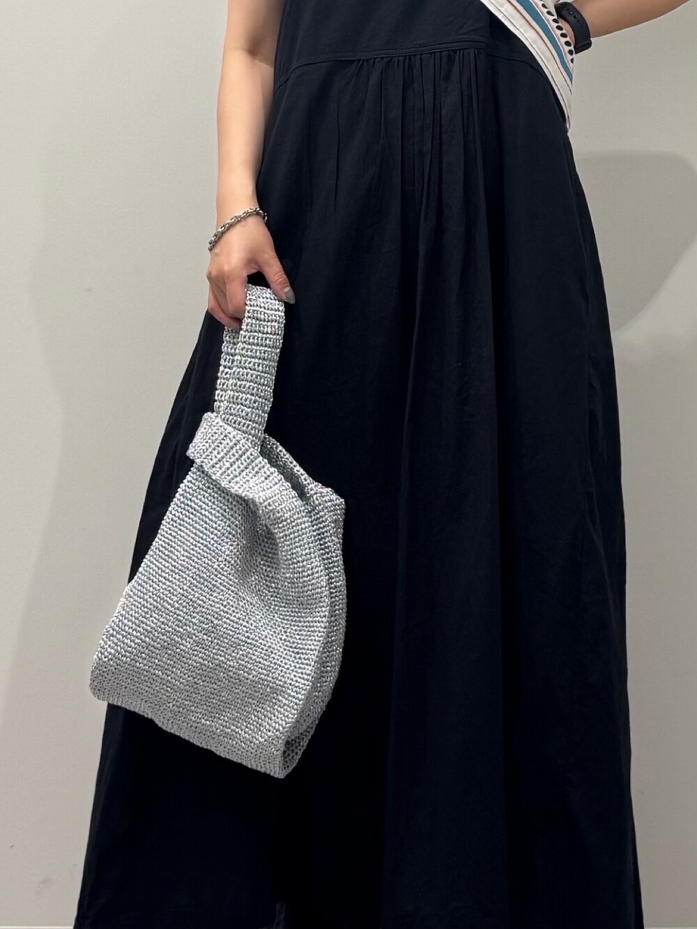 ブラック系のワンピース、シルバー系のかごバッグ、ブラック系のサンダルを着用したレディースの夏コーディネートの8枚目の写真