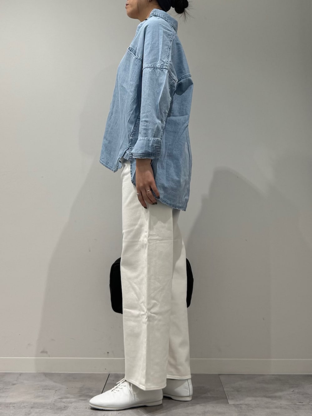 ブラック系のボストンバッグ、ホワイト系のデニムパンツ、ブルー系のシャツ/ブラウスを着用したレディースの春コーディネートの4枚目の写真