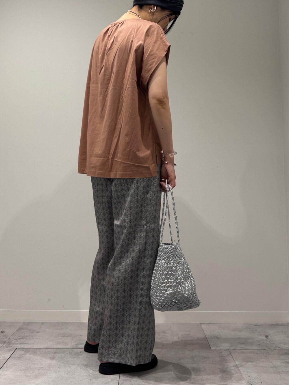 ピンク系のTシャツ/カットソー、シルバー系のかごバッグ、ベージュ系のその他パンツを着用したレディースの夏コーディネートの3枚目の写真