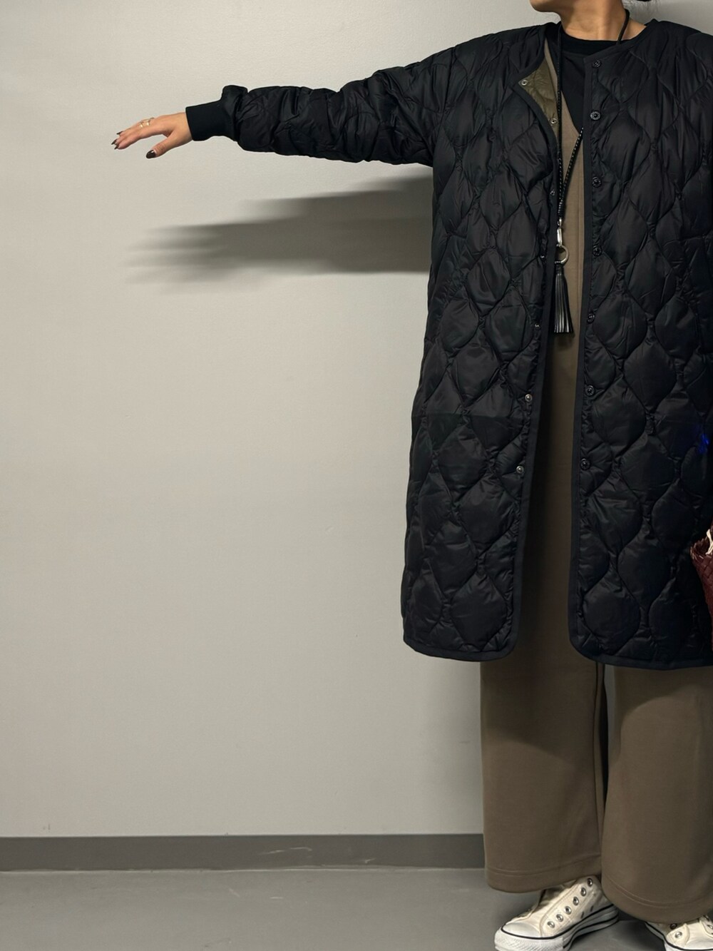 レッド系のショルダーバッグ、ブラウン系のサロペット/オーバーオール、ブラック系のシャツ/ブラウスを着用したレディースの秋コーディネートの6枚目の写真