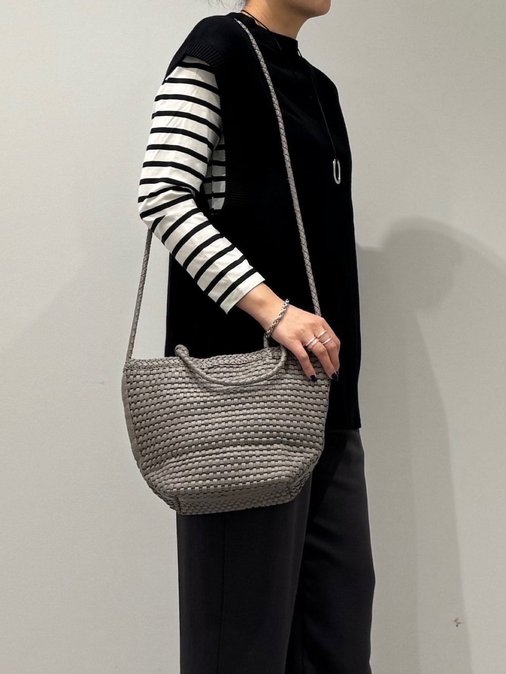 ベージュ系のトートバッグ、ブラック系のその他パンツ、ブラック系のTシャツ/カットソーを着用したレディースの秋コーディネートの7枚目の写真