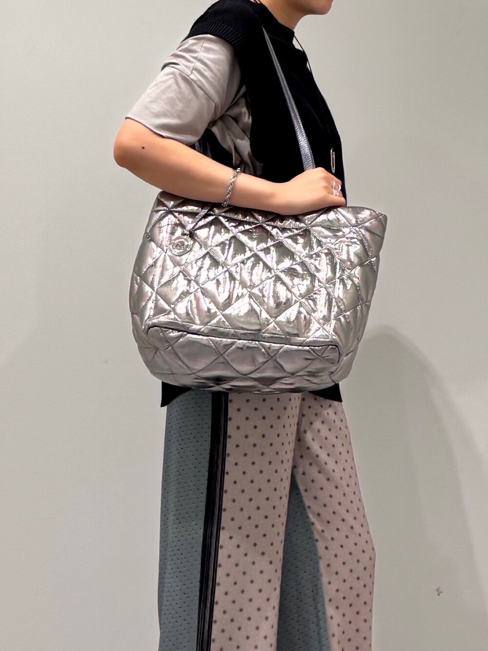 シルバー系のトートバッグ、ベージュ系のその他パンツ、ブラック系のベストを着用したレディースの秋コーディネートの8枚目の写真