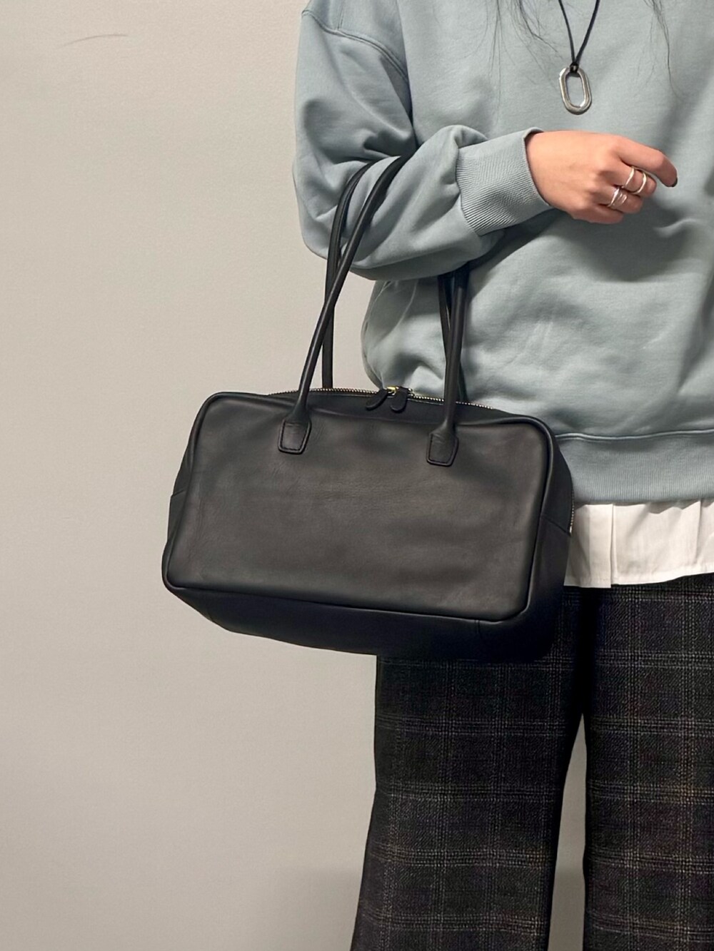 ブルー系のスウェット、ブラウン系のその他パンツ、ブラック系のボストンバッグを着用したレディースの冬コーディネートの8枚目の写真