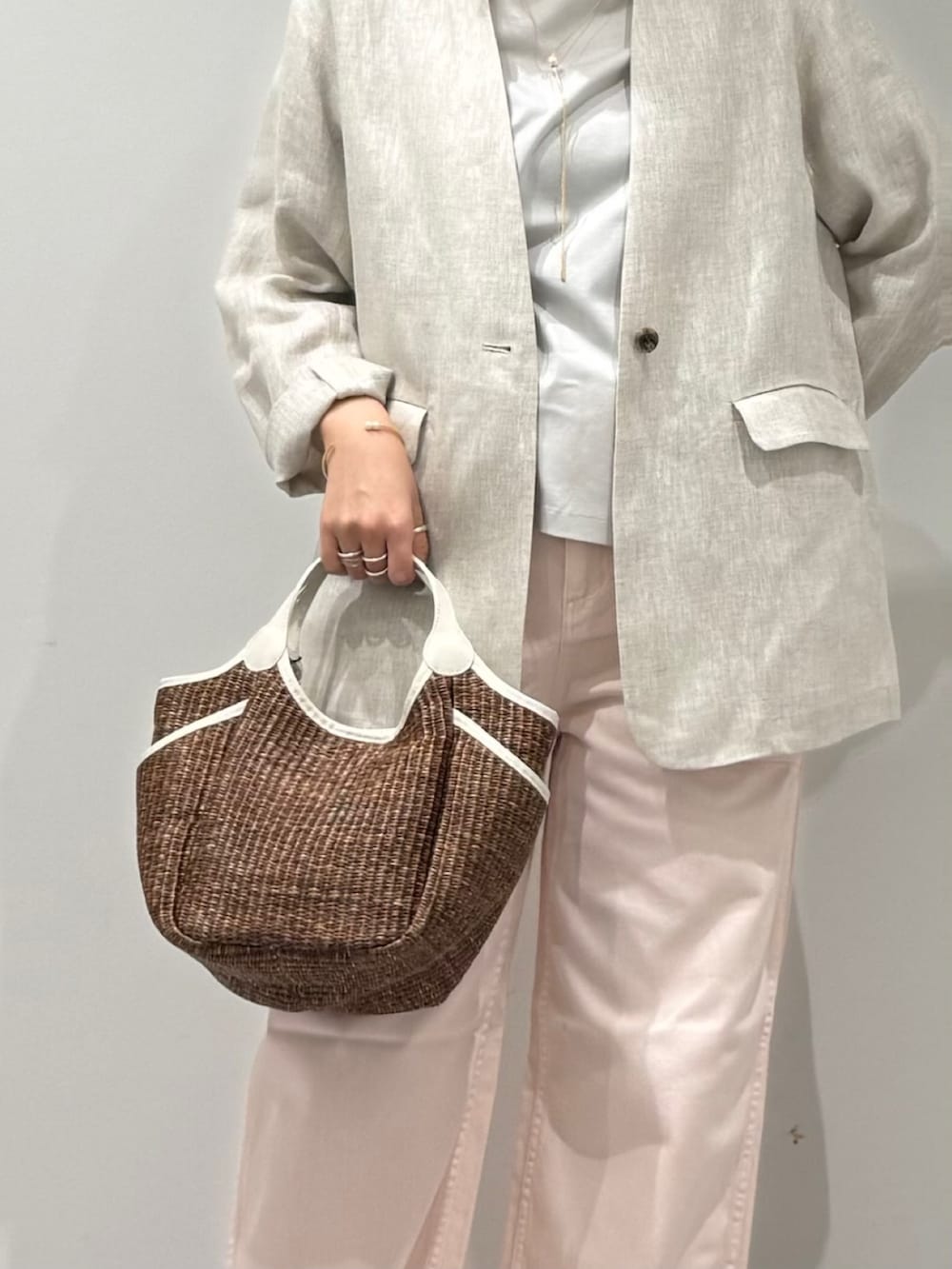 ピンク系のその他パンツ、ブラウン系のかごバッグ、ベージュ系のノーカラージャケットを着用したレディースの春コーディネートの8枚目の写真