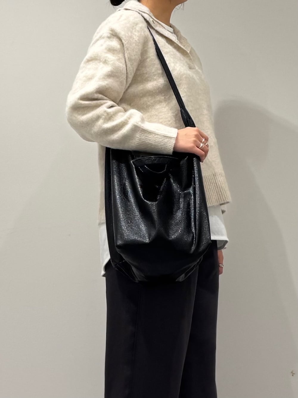 ブラック系のトートバッグ、ホワイト系のニット/セーター、ホワイト系のTシャツ/カットソーを着用したレディースの冬コーディネートの9枚目の写真