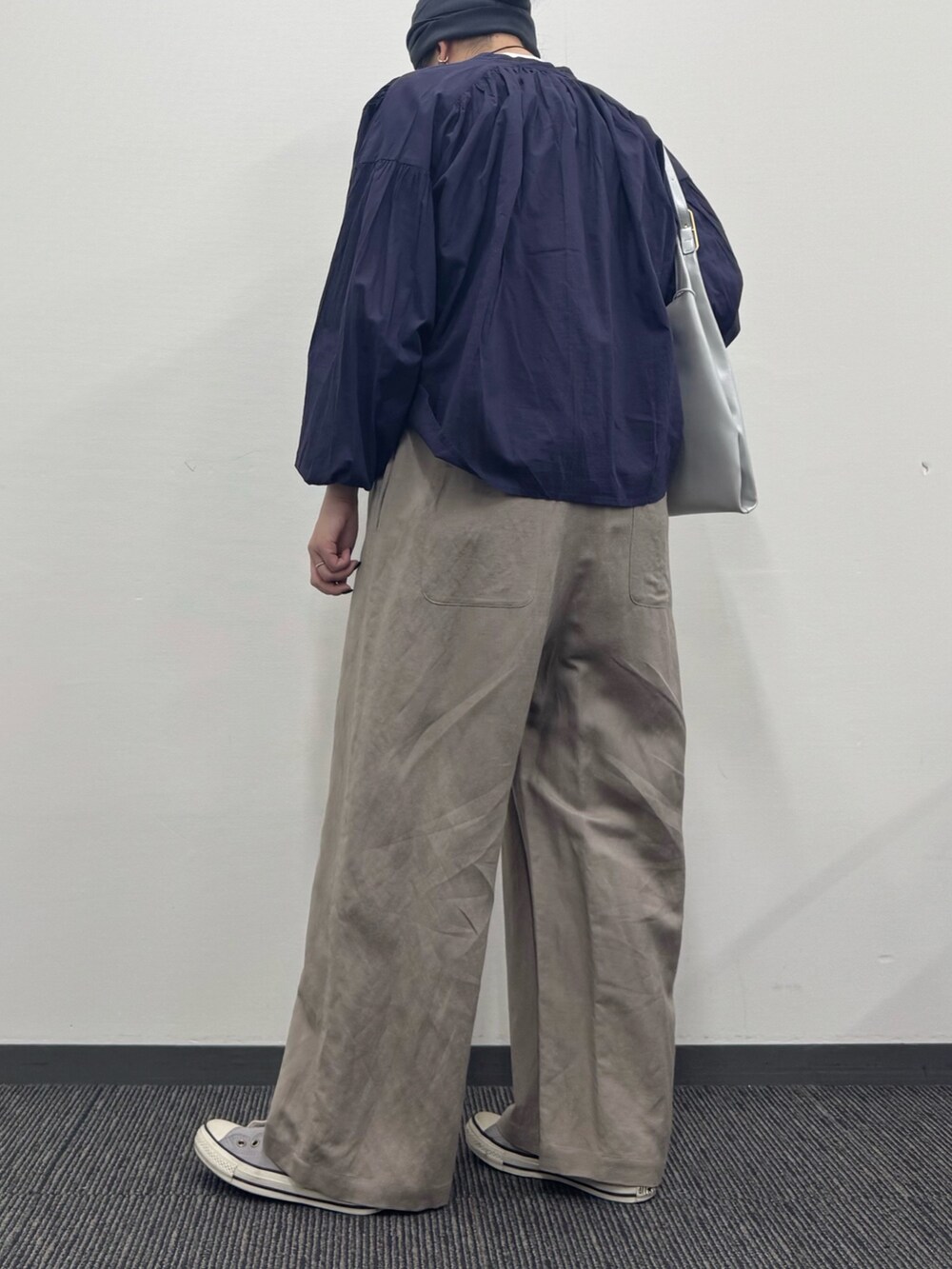 シルバー系のトートバッグ、ベージュ系のサロペット/オーバーオール、ホワイト系のTシャツ/カットソーを着用したレディースの春コーディネートの4枚目の写真