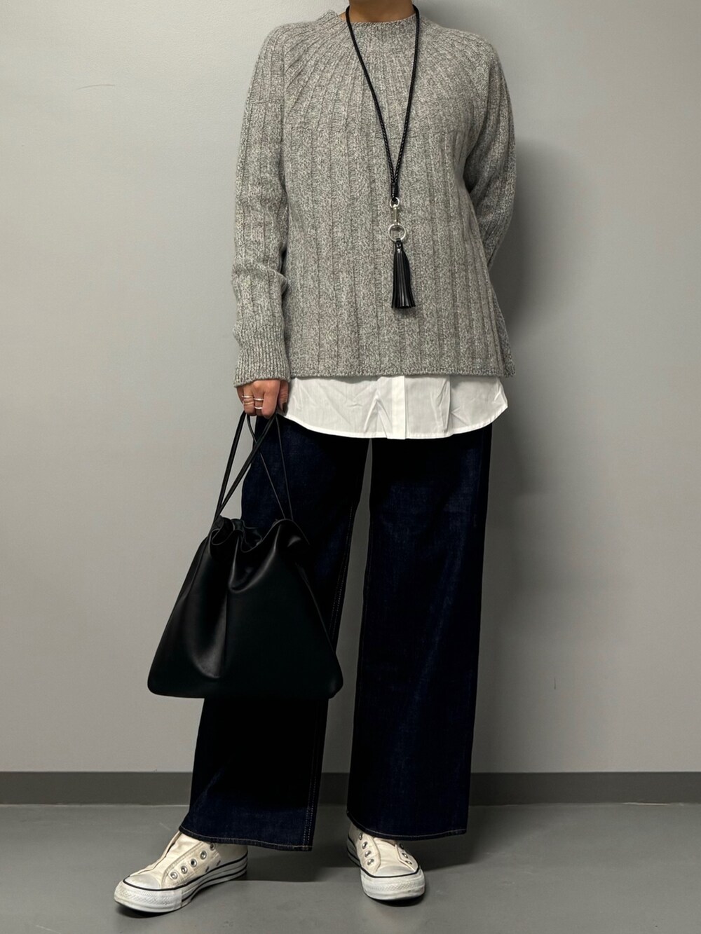 ブルー系のデニムパンツ、ブラック系のショルダーバッグ、グレー系のニット/セーターを着用したレディースの秋コーディネートの3枚目の写真