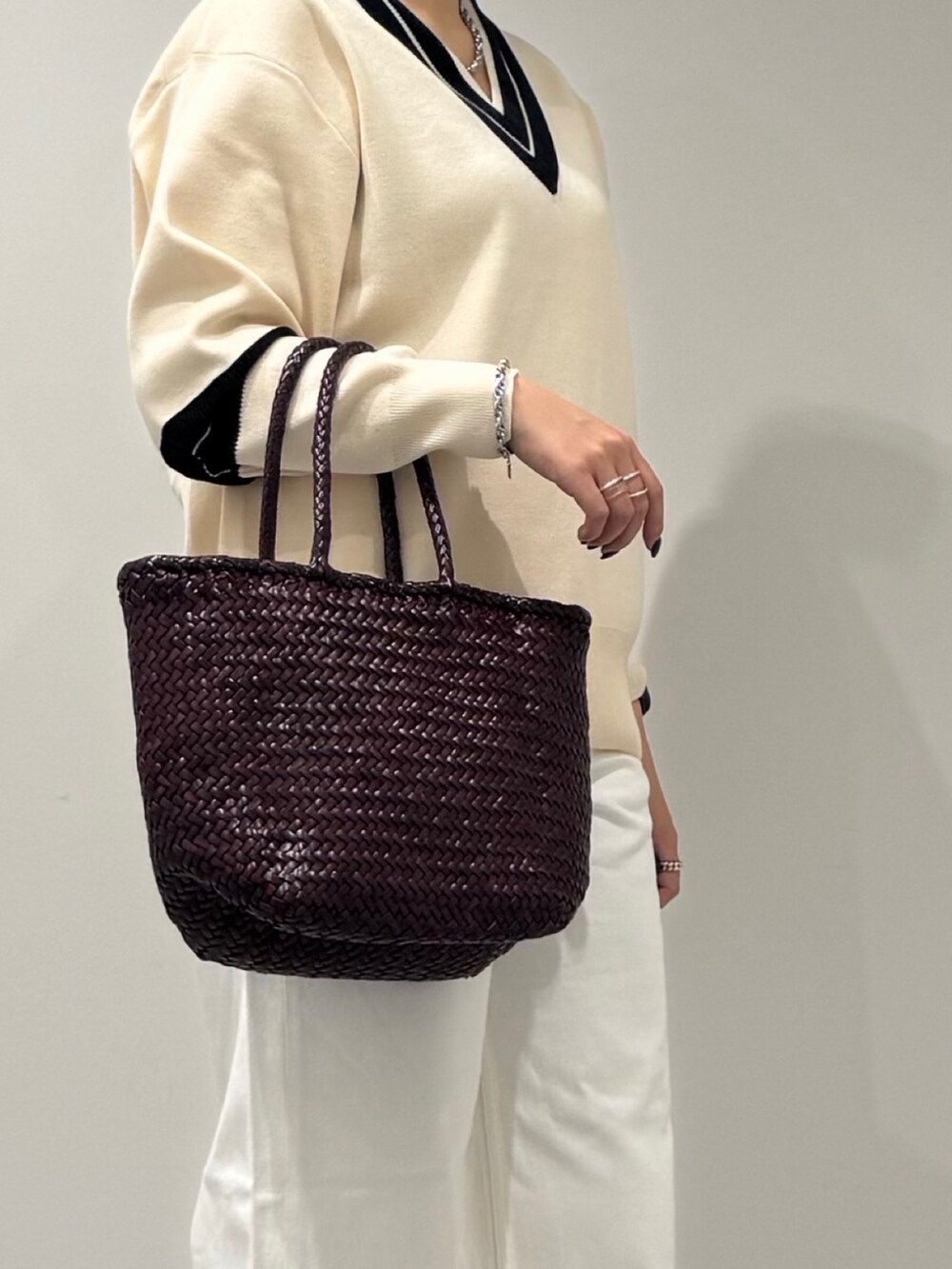 パープル系のトートバッグ、ホワイト系のデニムパンツ、ブラック系のローファーを着用したレディースの冬コーディネートの8枚目の写真