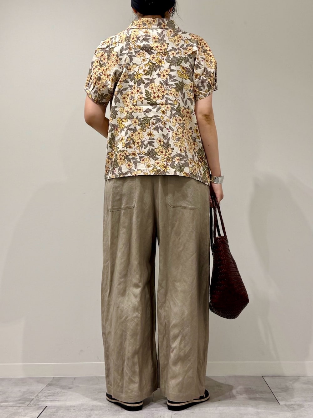 ブラウン系のトートバッグ、ベージュ系のサロペット/オーバーオール、ブラック系のサンダルを着用したレディースの春コーディネートの4枚目の写真