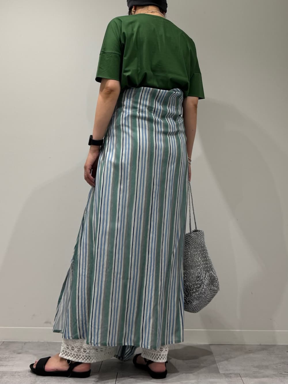 シルバー系のかごバッグ、ホワイト系のその他パンツ、ブラック系のサンダルを着用したレディースの夏コーディネートの3枚目の写真