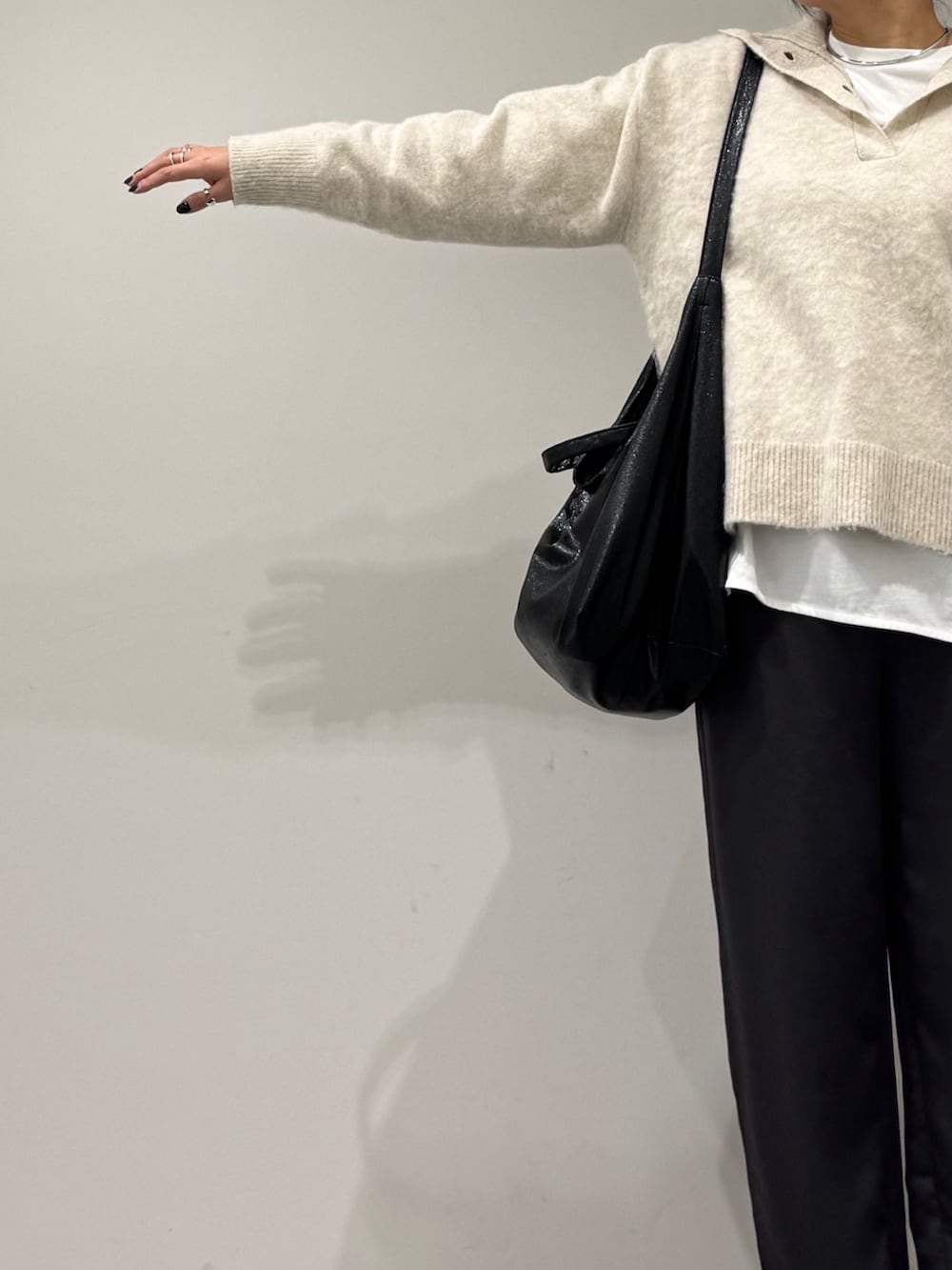 ブラック系のトートバッグ、ホワイト系のニット/セーター、ホワイト系のTシャツ/カットソーを着用したレディースの冬コーディネートの6枚目の写真