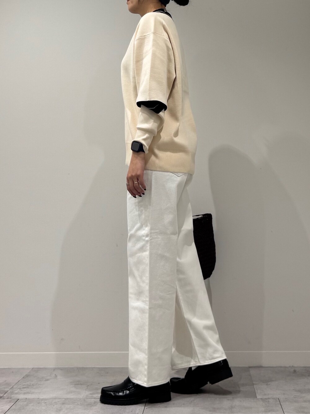 パープル系のトートバッグ、ホワイト系のデニムパンツ、ブラック系のローファーを着用したレディースの冬コーディネートの5枚目の写真