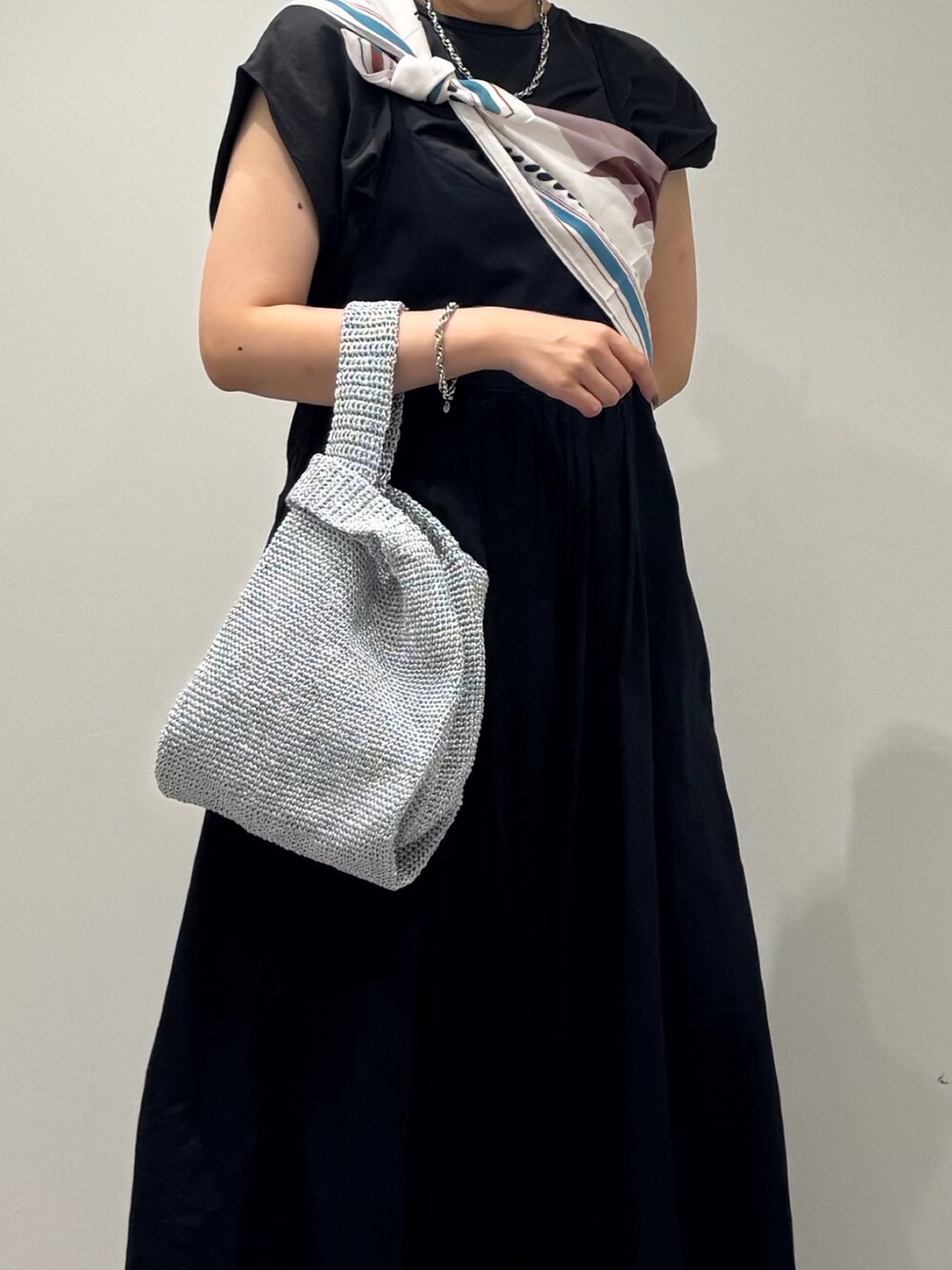 ブラック系のワンピース、シルバー系のかごバッグ、ブラック系のサンダルを着用したレディースの夏コーディネートの7枚目の写真