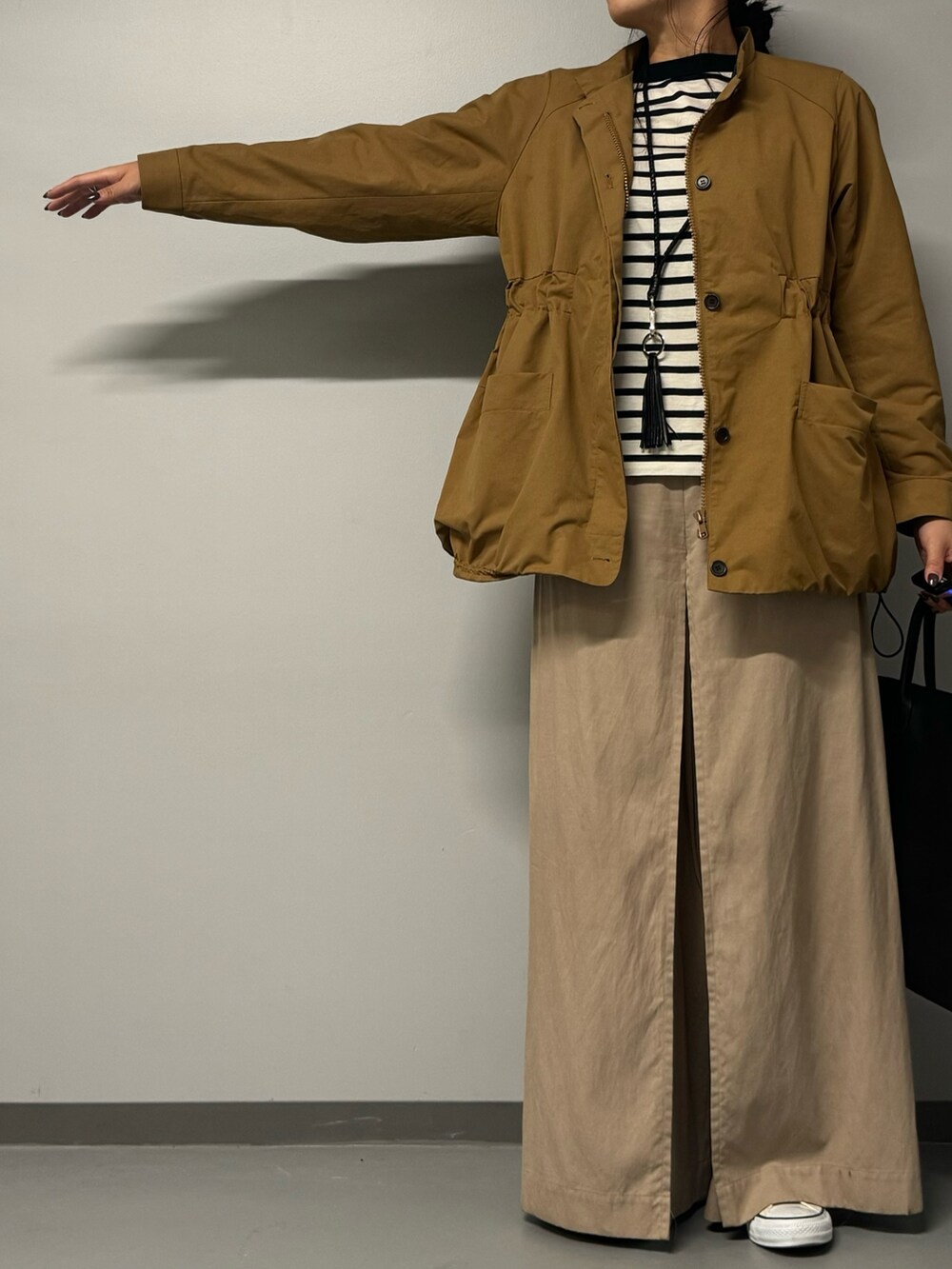 ブラック系のトートバッグ、ベージュ系のブルゾン、ブラック系のTシャツ/カットソーを着用したレディースの秋コーディネートの9枚目の写真