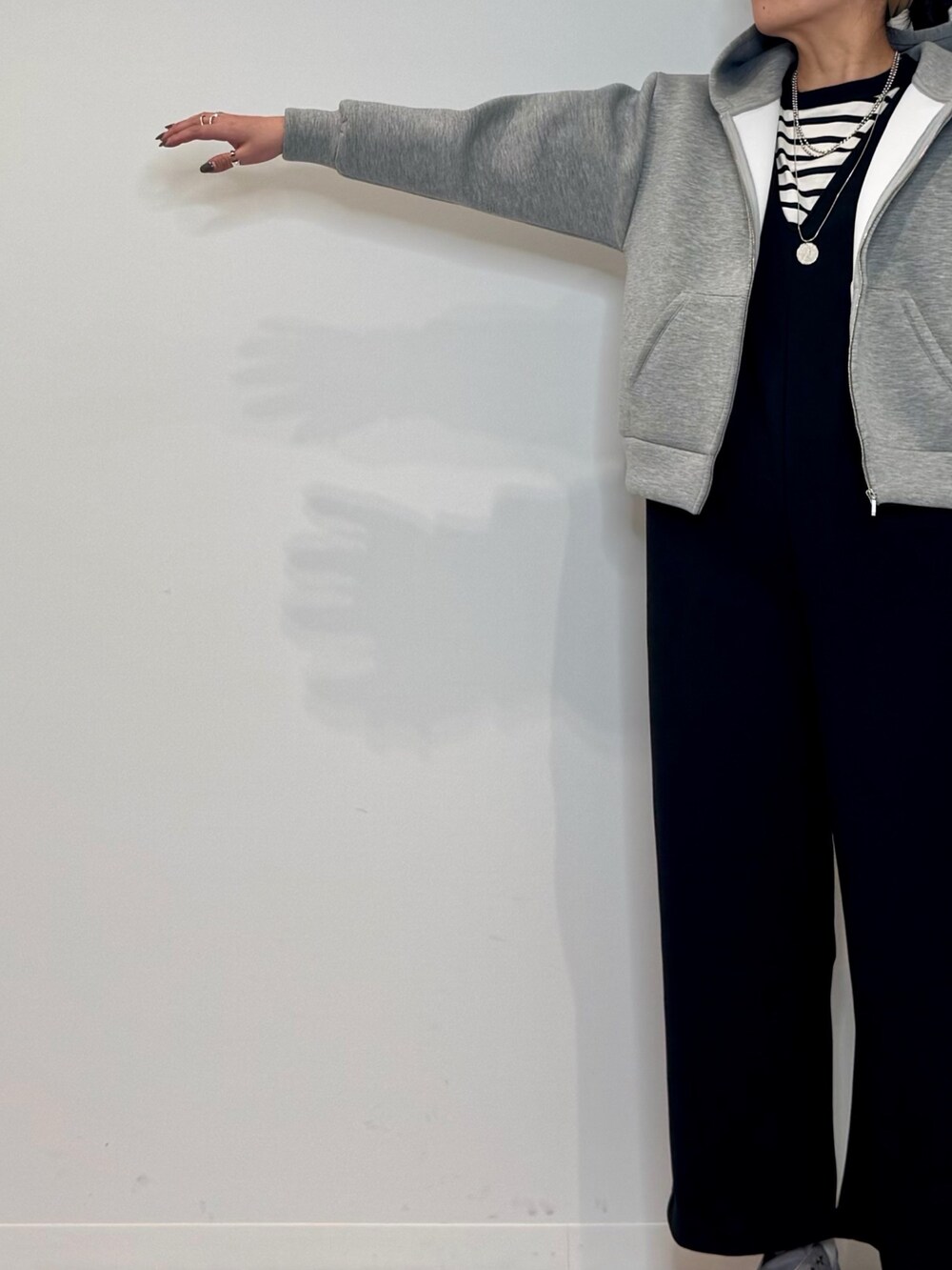 シルバー系のトートバッグ、ブラック系のサロペット/オーバーオール、グレー系のパーカーを着用したレディースの冬コーディネートの6枚目の写真