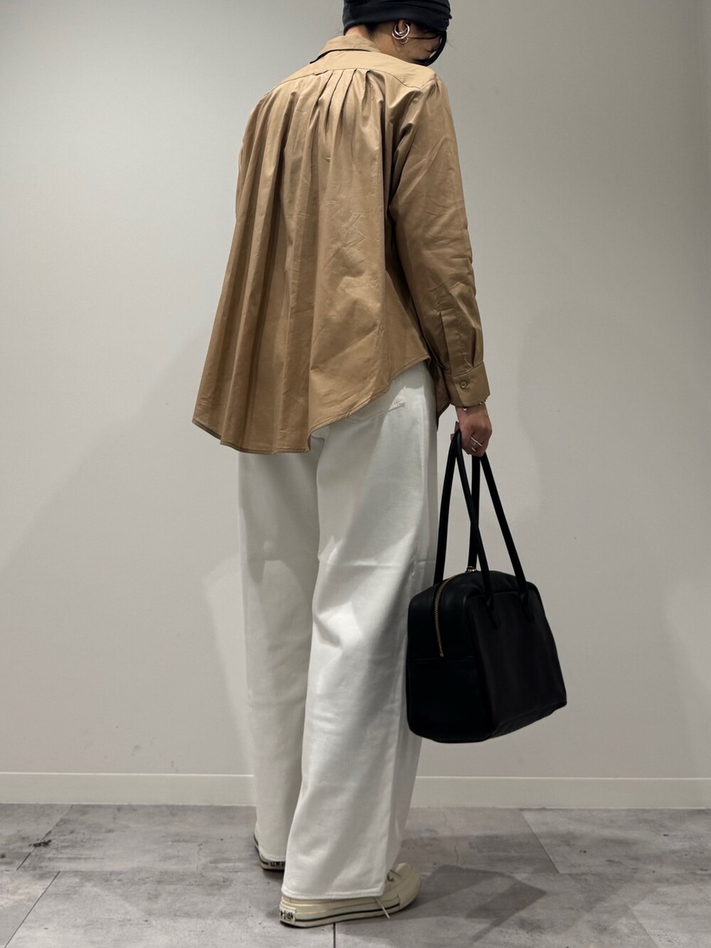 ベージュ系のシャツ/ブラウス、ホワイト系のデニムパンツ、ブラック系のボストンバッグを着用したレディースの秋コーディネートの3枚目の写真