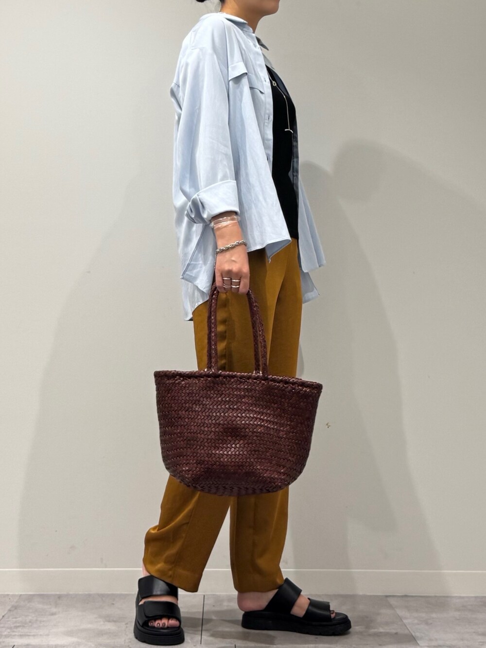 ブラウン系のトートバッグ、ブラウン系のその他パンツ、ブラック系のサンダルを着用したレディースの秋コーディネートの2枚目の写真