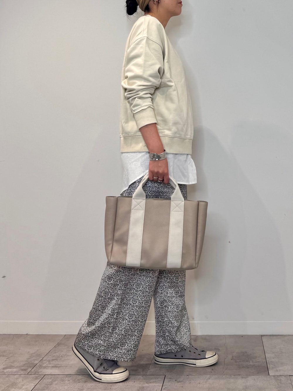 ホワイト系のスウェット、ベージュ系のトートバッグ、ブラック系のその他パンツを着用したレディースの秋コーディネートの2枚目の写真