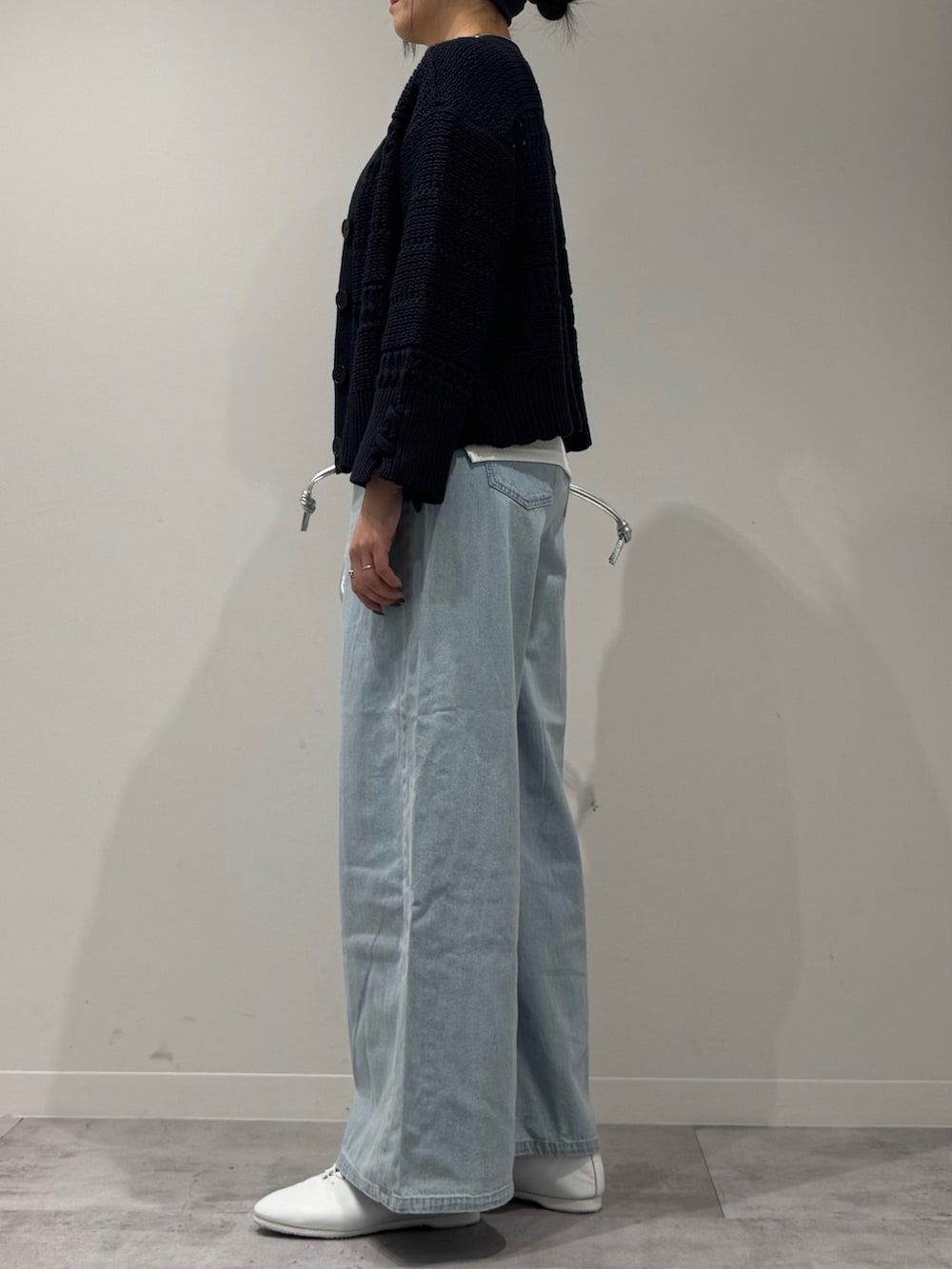 シルバー系のショルダーバッグ、ブルー系のデニムパンツ、ホワイト系のタンクトップを着用したレディースの春コーディネートの5枚目の写真