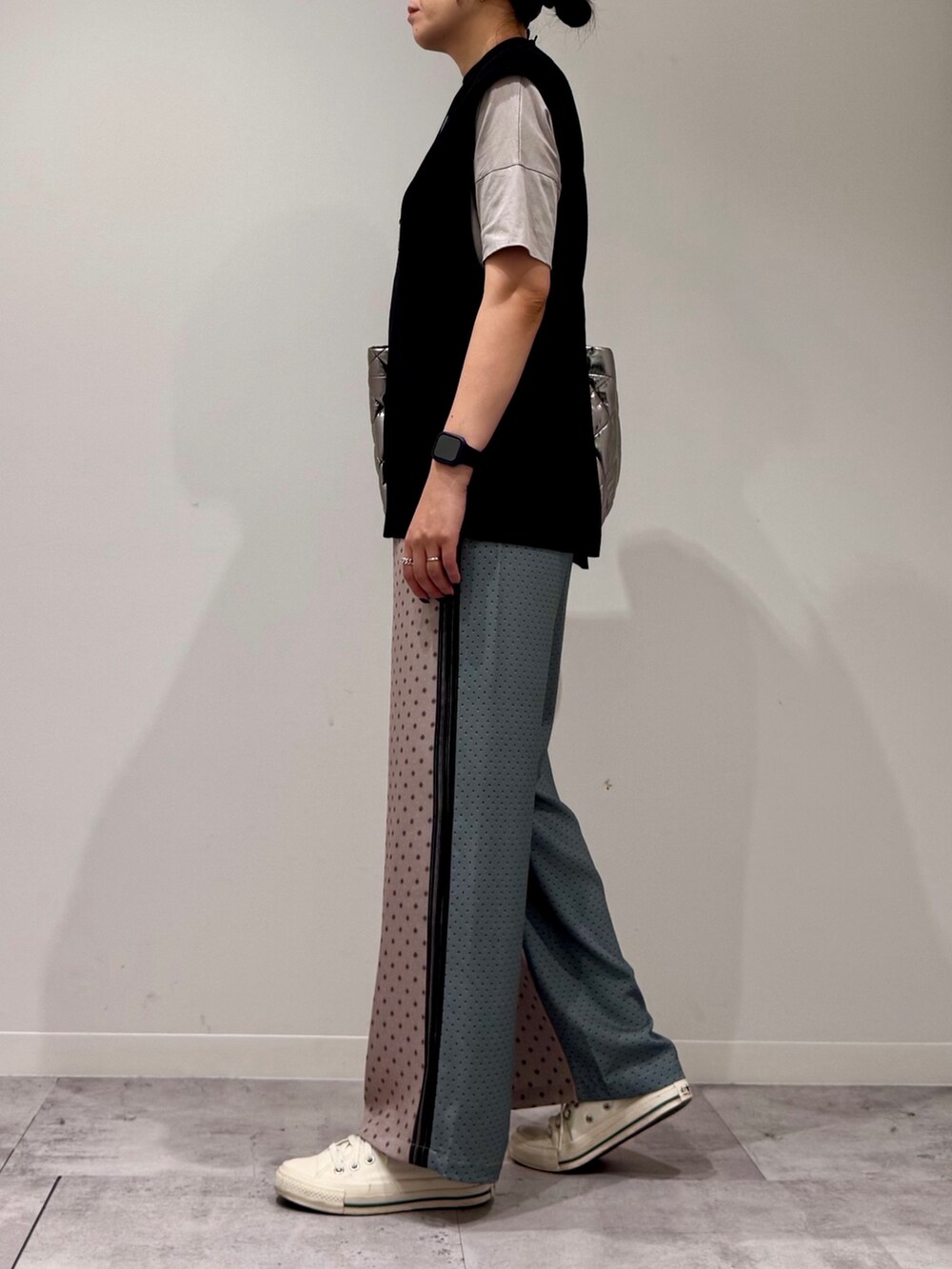 シルバー系のトートバッグ、ベージュ系のその他パンツ、ブラック系のベストを着用したレディースの秋コーディネートの5枚目の写真