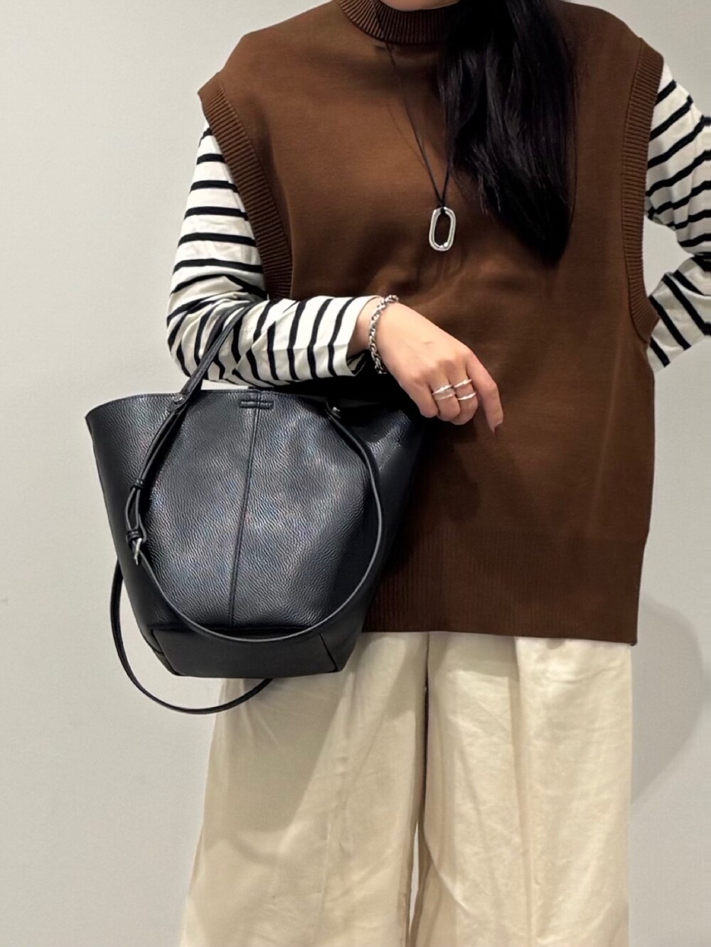 ブラック系のトートバッグ、ブラック系のTシャツ/カットソー、ホワイト系のその他パンツを着用したレディースの冬コーディネートの8枚目の写真