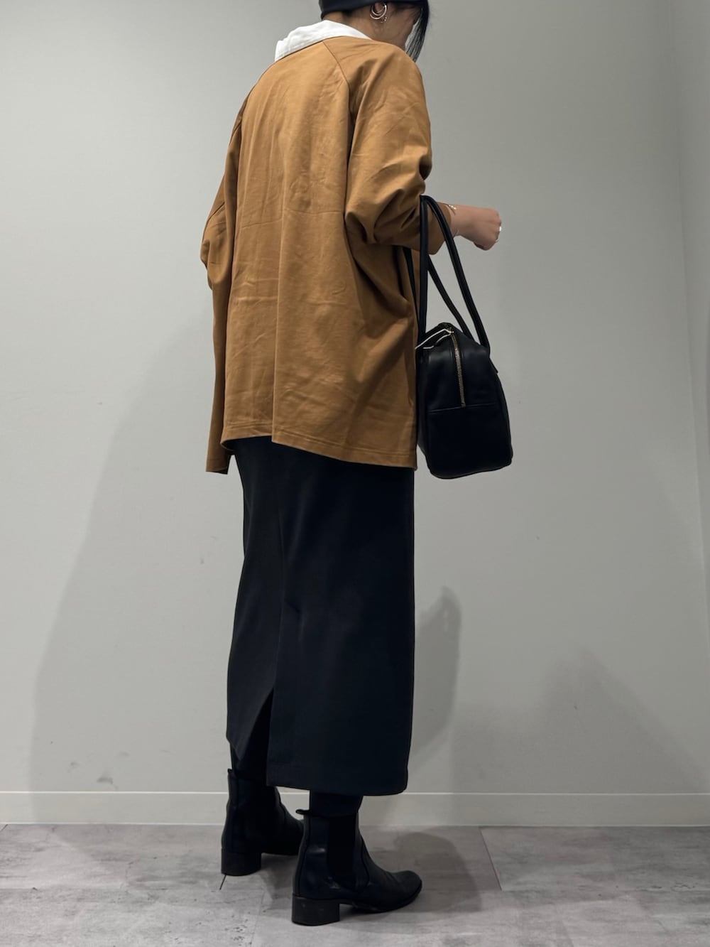 ブラック系のボストンバッグ、ベージュ系のTシャツ/カットソー、シルバー系のネックレスを着用したレディースの冬コーディネートの3枚目の写真