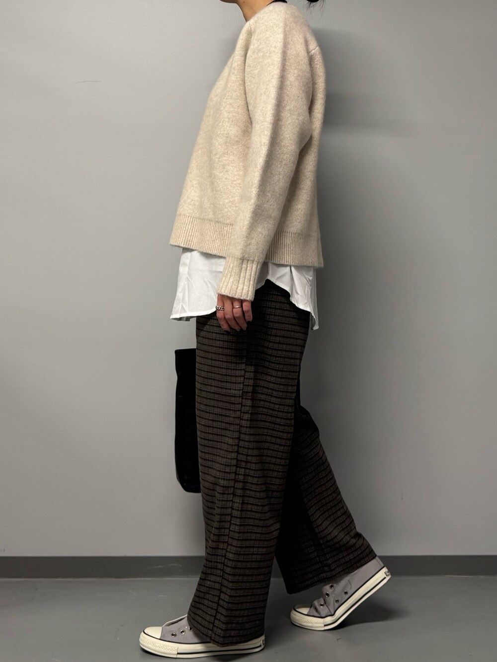 ベージュ系のニット/セーター、ブラウン系のその他パンツ、ブラック系のトートバッグを着用したレディースの冬コーディネートの5枚目の写真