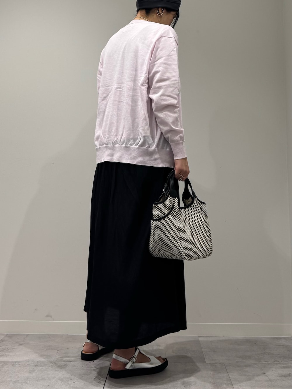 ブラック系のかごバッグ、ピンク系のカーディガン/ボレロ、ホワイト系のTシャツ/カットソーを着用したレディースの春コーディネートの3枚目の写真