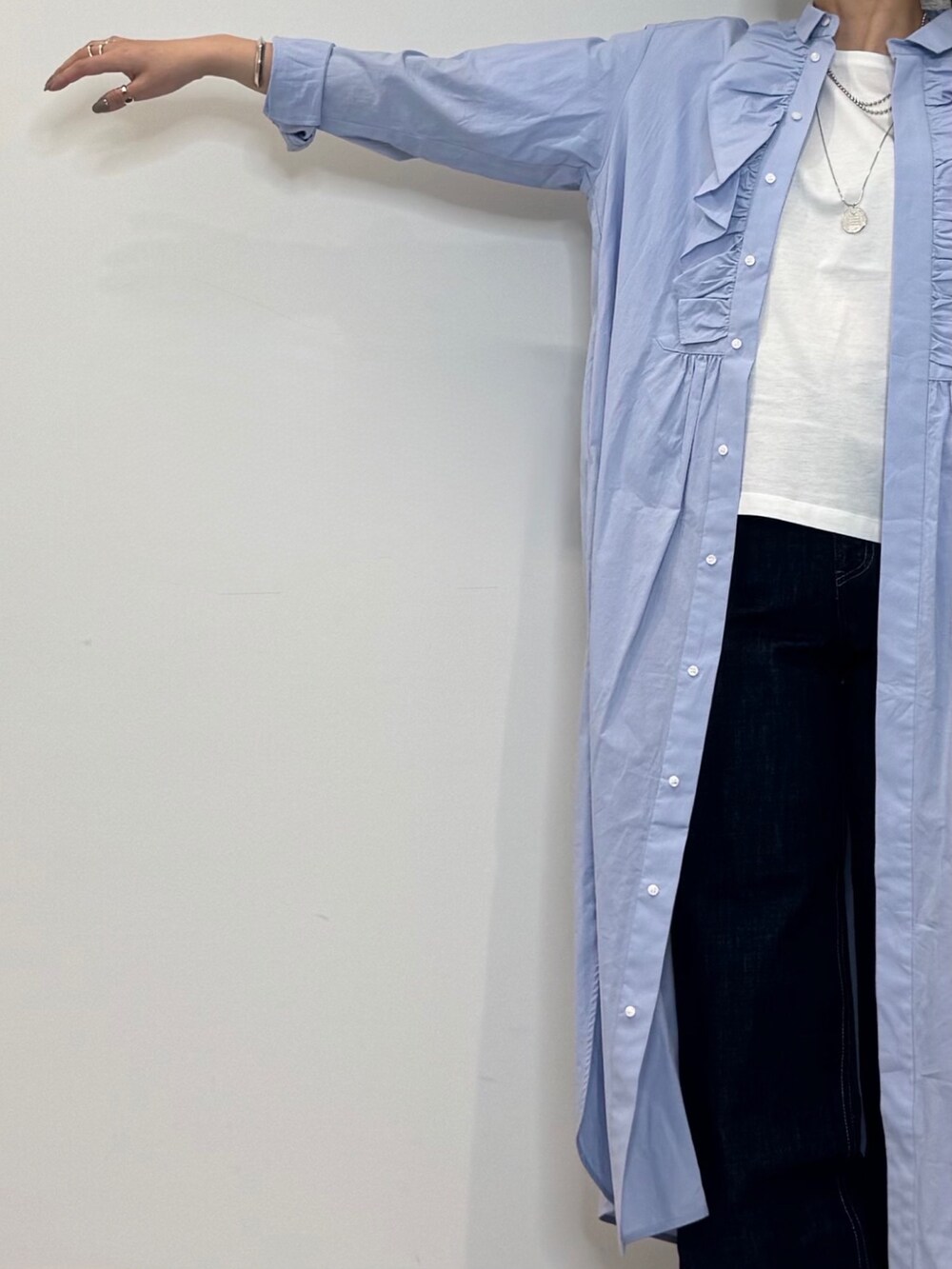 ブルー系のシャツワンピース、シルバー系のかごバッグ、ブルー系のデニムパンツを着用したレディースの春コーディネートの7枚目の写真