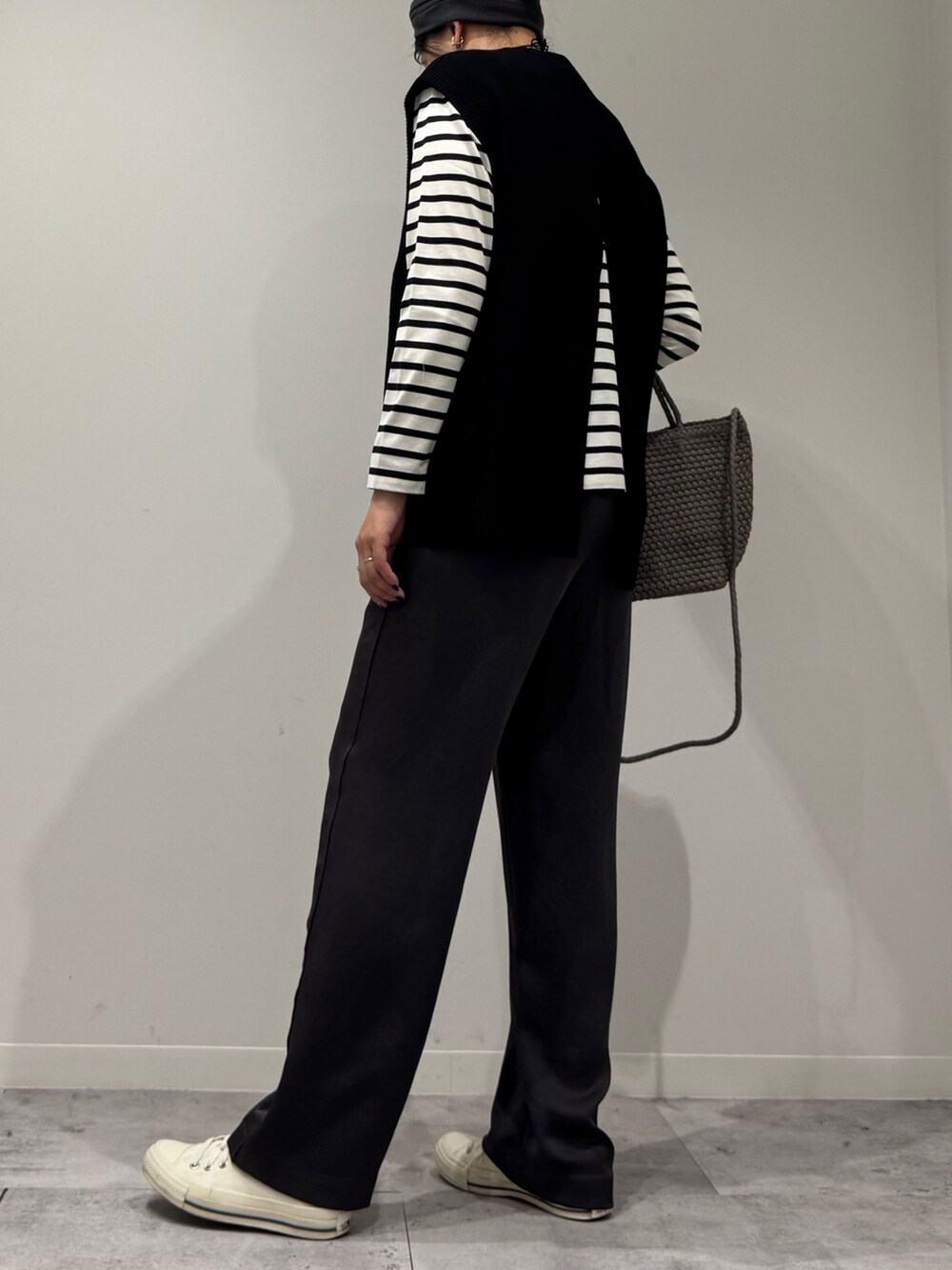 ベージュ系のトートバッグ、ブラック系のその他パンツ、ブラック系のTシャツ/カットソーを着用したレディースの秋コーディネートの4枚目の写真