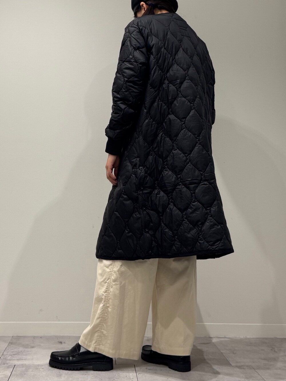 イエロー系のボストンバッグ、ブラウン系のベスト、ホワイト系のその他パンツを着用したレディースの秋コーディネートの4枚目の写真