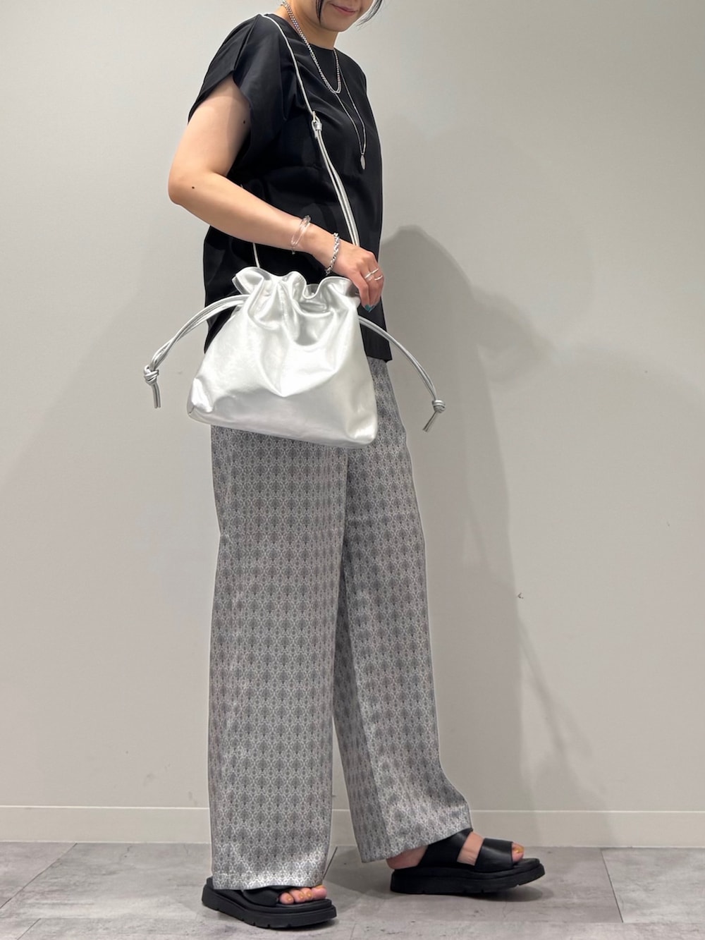 シルバー系のショルダーバッグ、グレー系のTシャツ/カットソー、ベージュ系のその他パンツを着用したレディースの秋コーディネートの2枚目の写真