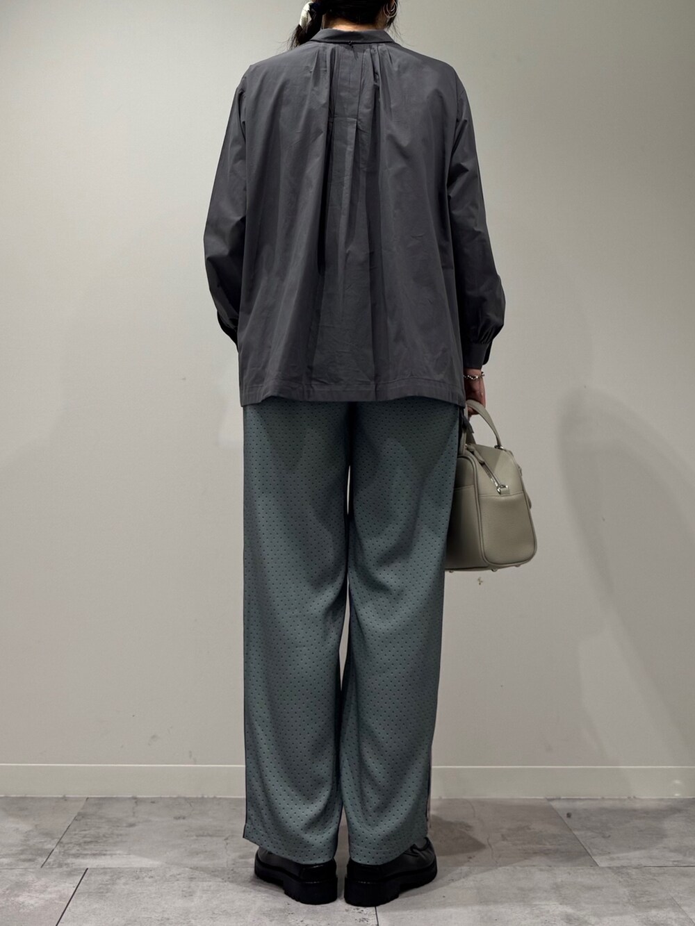 グレー系のボストンバッグ、ベージュ系のその他パンツ、ブラック系のローファーを着用したレディースの秋コーディネートの3枚目の写真