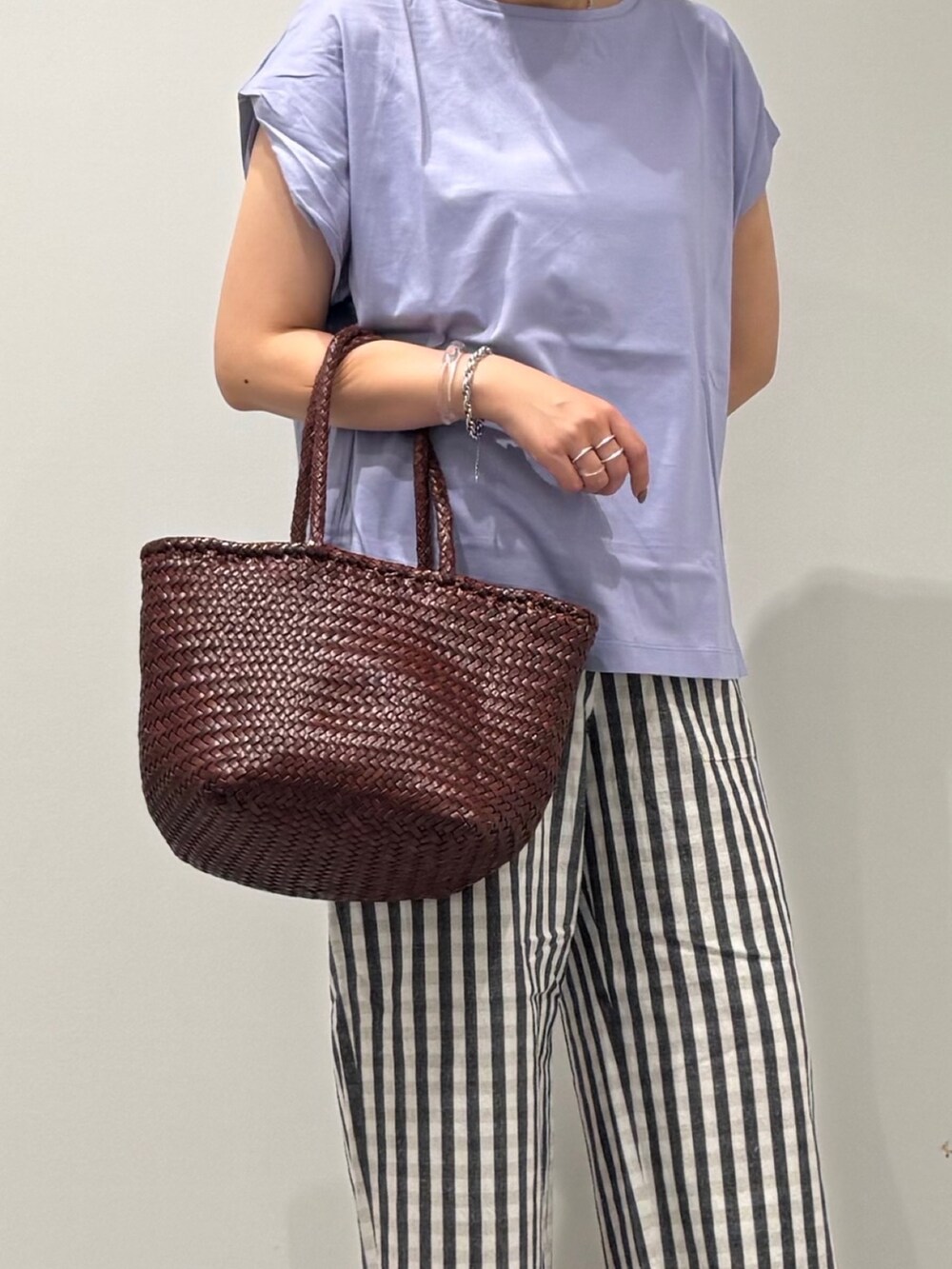 ブラウン系のトートバッグ、ブラック系のその他パンツ、ブラック系のサンダルを着用したレディースの秋コーディネートの6枚目の写真