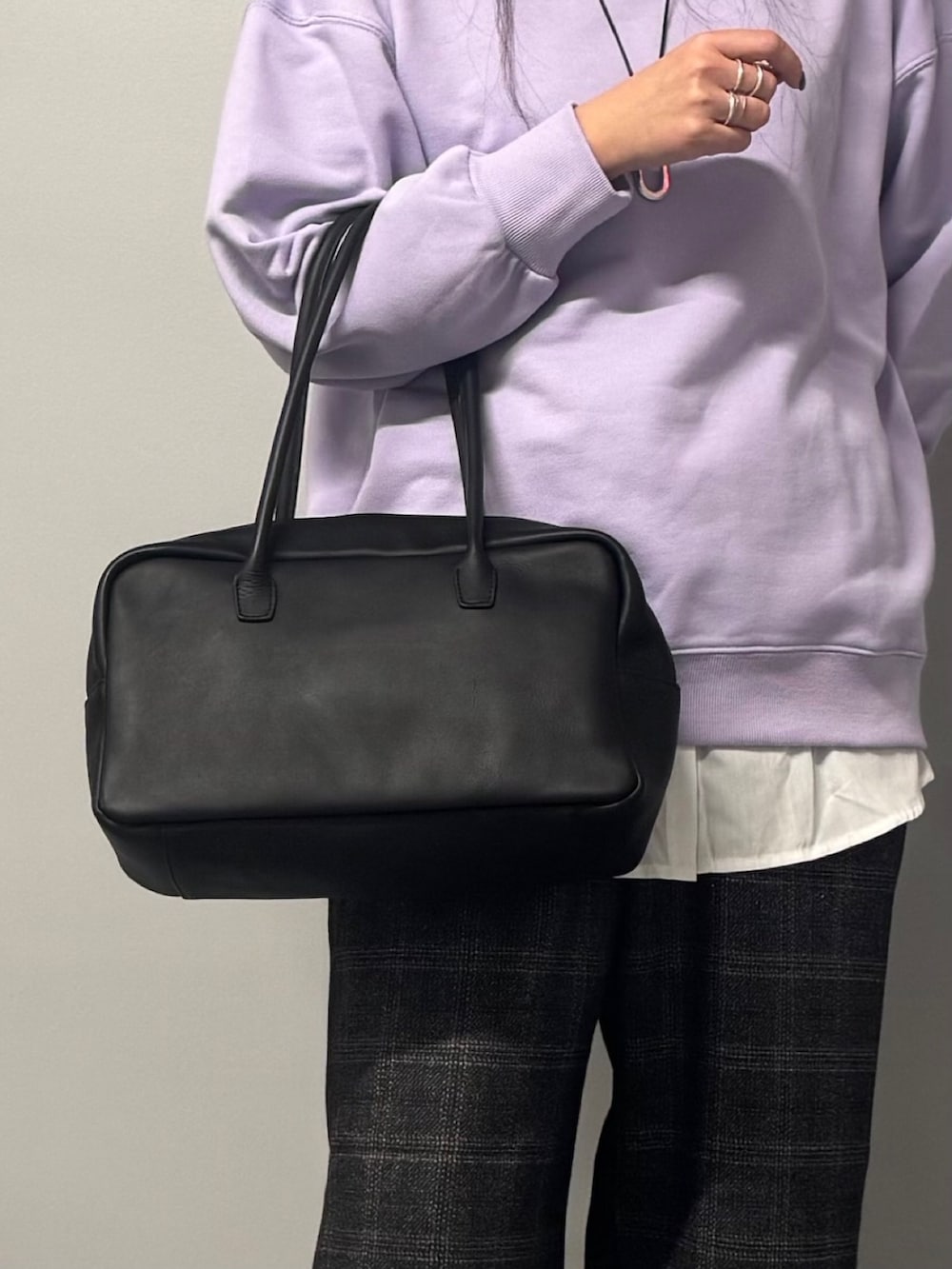 パープル系のスウェット、ブラック系のボストンバッグ、ブラウン系のその他パンツを着用したレディースの冬コーディネートの8枚目の写真