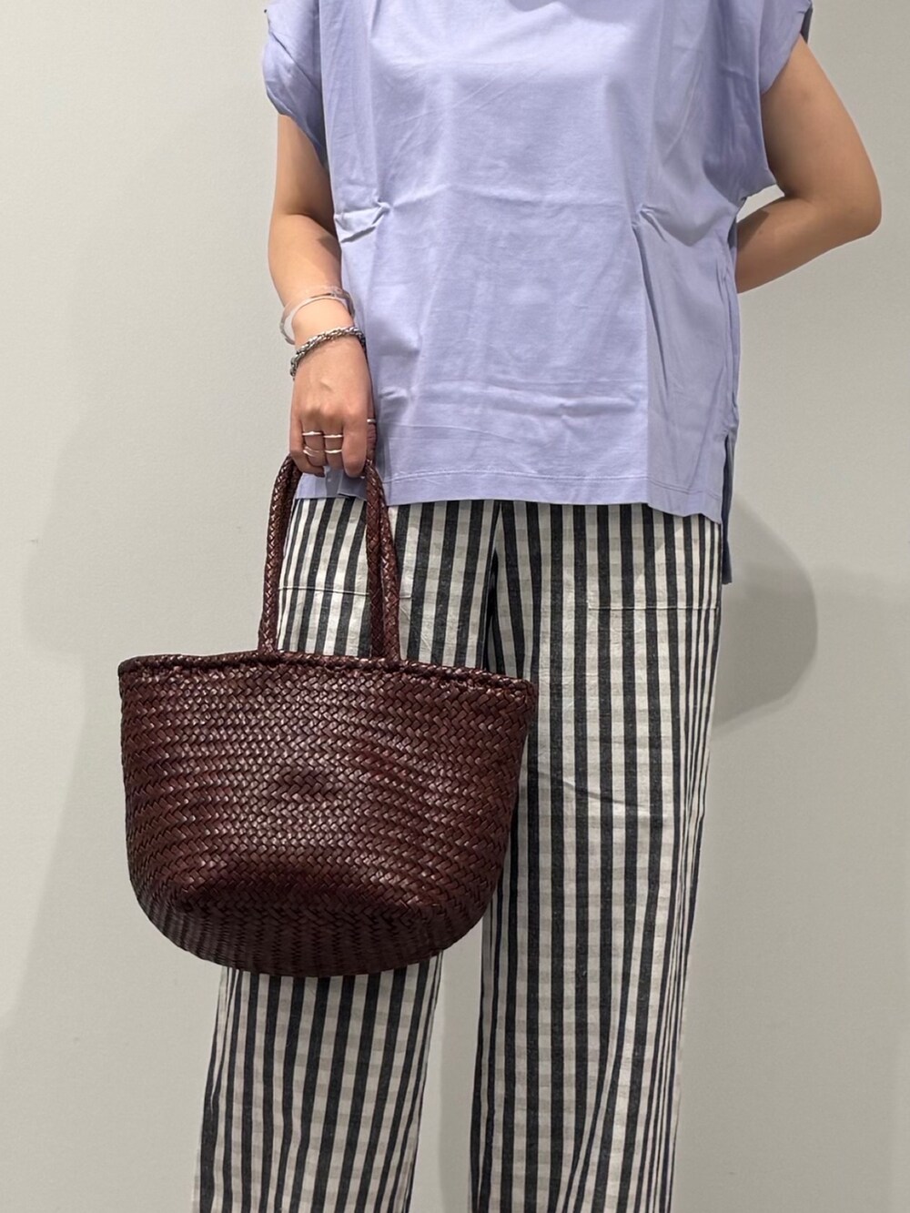 ブラウン系のトートバッグ、ブラック系のその他パンツ、ブラック系のサンダルを着用したレディースの秋コーディネートの8枚目の写真