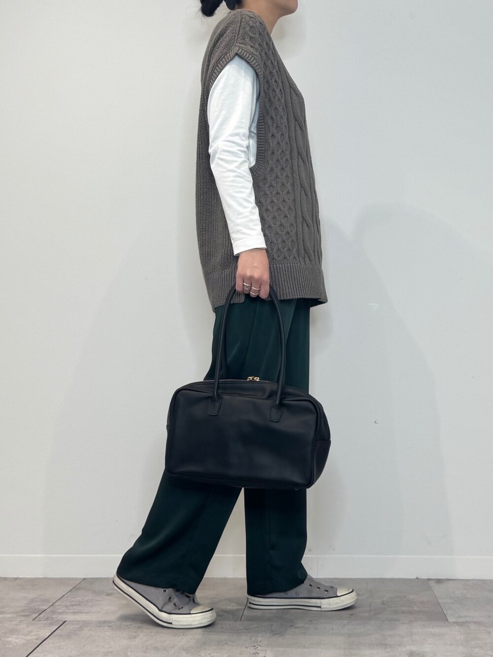 グリーン系のその他パンツ、ベージュ系のニット/セーター、ホワイト系のTシャツ/カットソーを着用したレディースの冬コーディネートの2枚目の写真