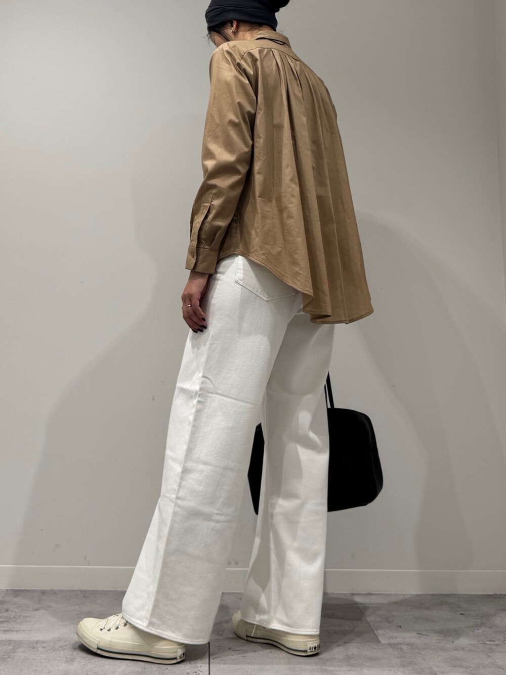 ベージュ系のシャツ/ブラウス、ホワイト系のデニムパンツ、ブラック系のボストンバッグを着用したレディースの秋コーディネートの5枚目の写真