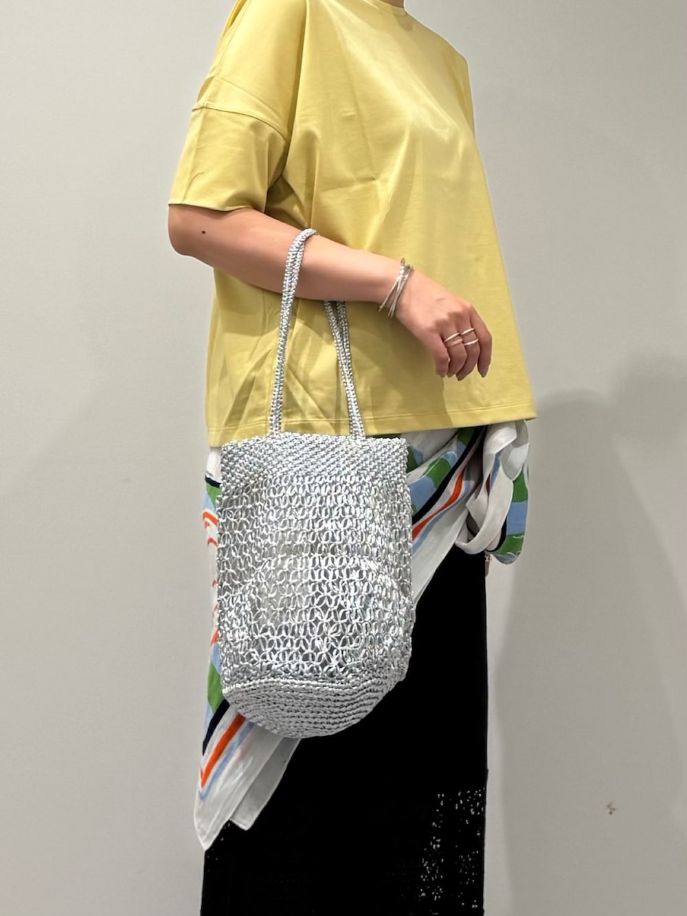シルバー系のかごバッグ、ブラック系のその他パンツ、ブラック系のサンダルを着用したレディースの夏コーディネートの6枚目の写真