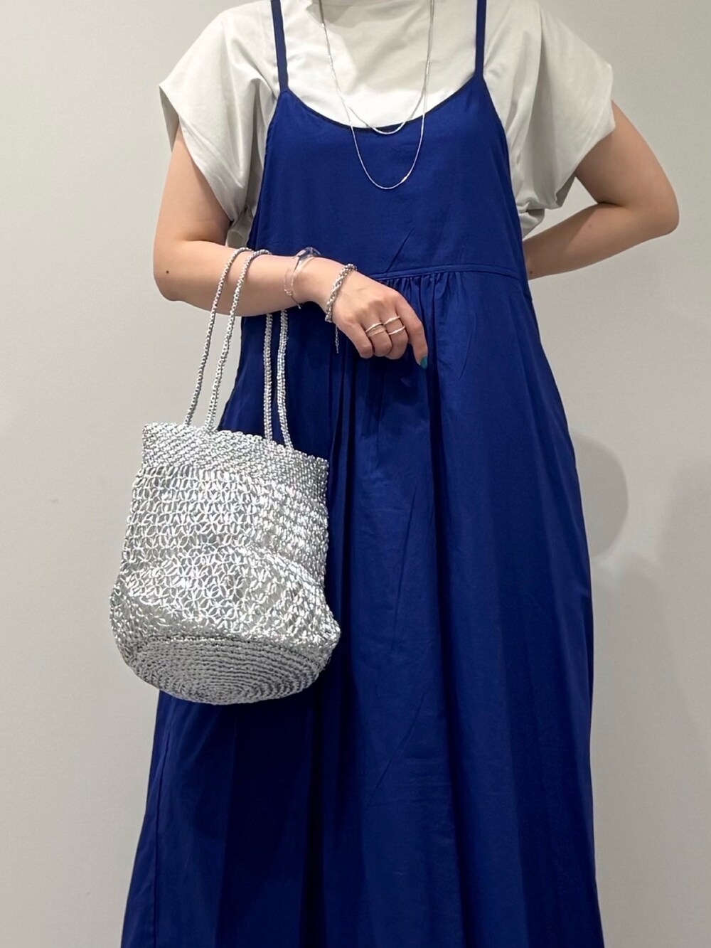 ブルー系のワンピース、シルバー系のかごバッグ、ブラック系のサンダルを着用したレディースの夏コーディネートの7枚目の写真