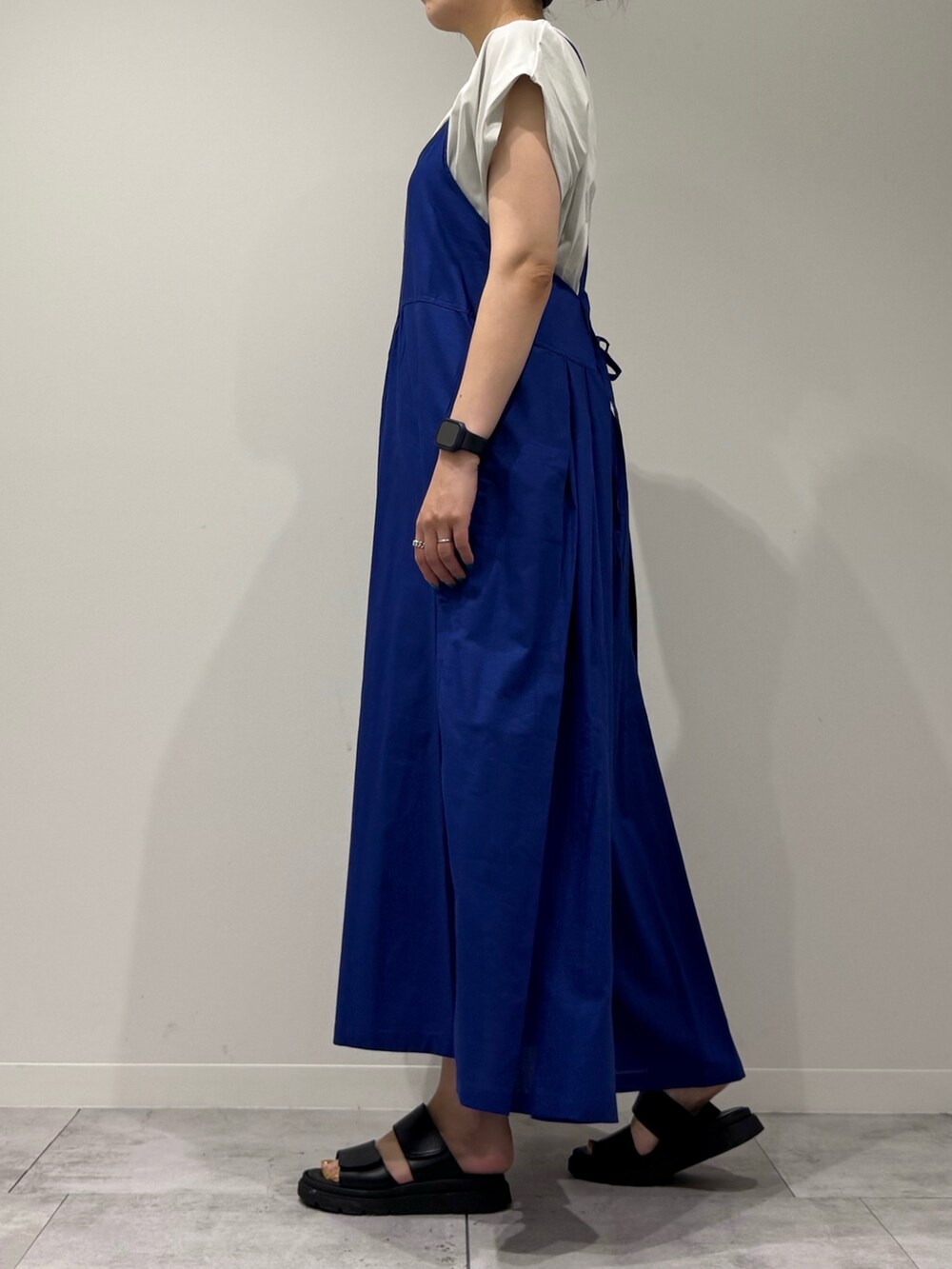 ブルー系のワンピース、シルバー系のかごバッグ、ブラック系のサンダルを着用したレディースの夏コーディネートの5枚目の写真