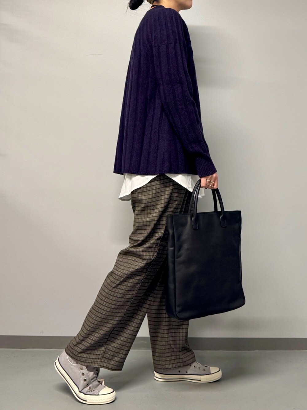 ブルー系のニット/セーター、ブラック系のトートバッグ、ブラウン系のその他パンツを着用したレディースの冬コーディネートの3枚目の写真