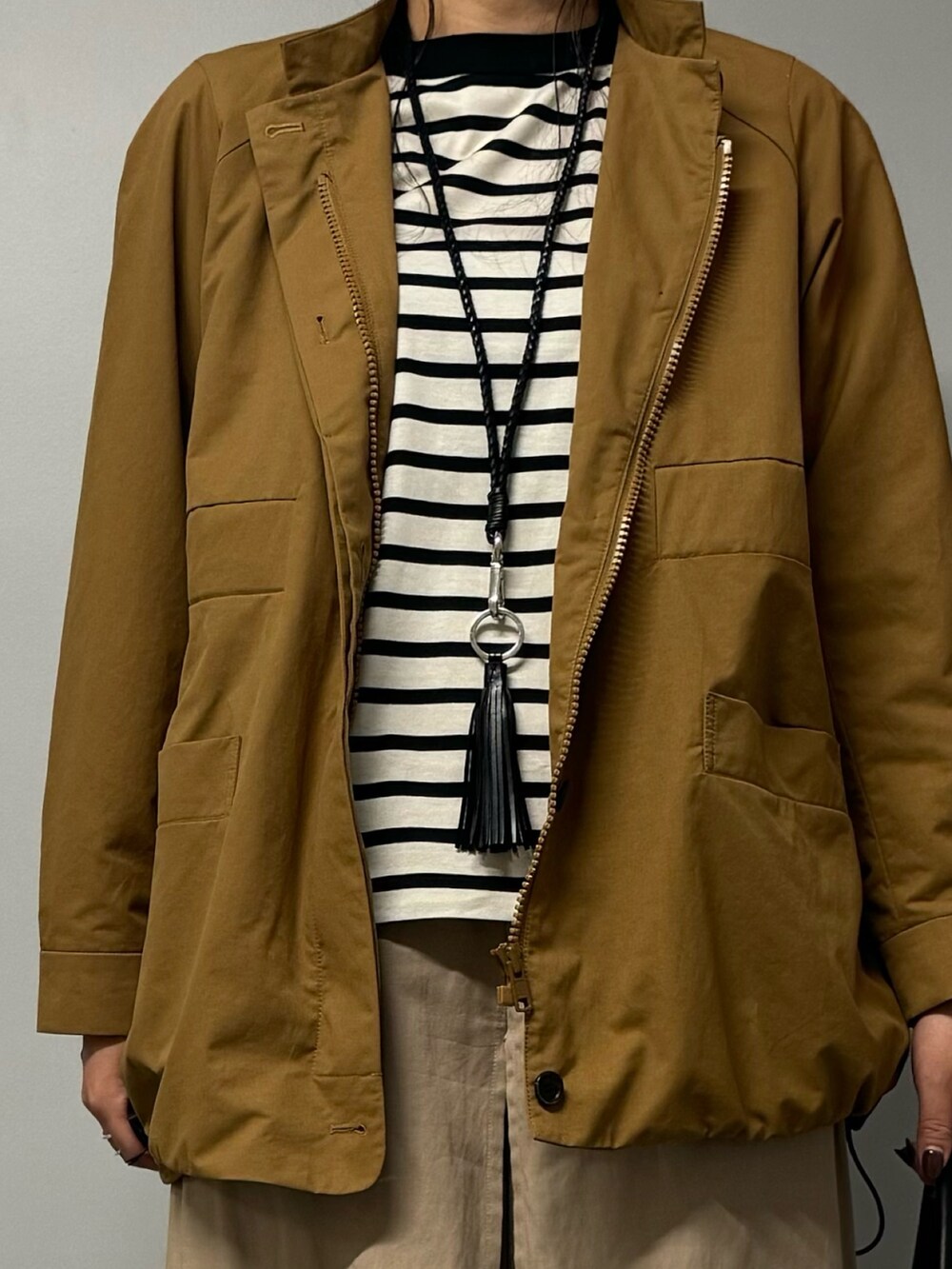 ブラック系のトートバッグ、ベージュ系のブルゾン、ブラック系のTシャツ/カットソーを着用したレディースの秋コーディネートの4枚目の写真