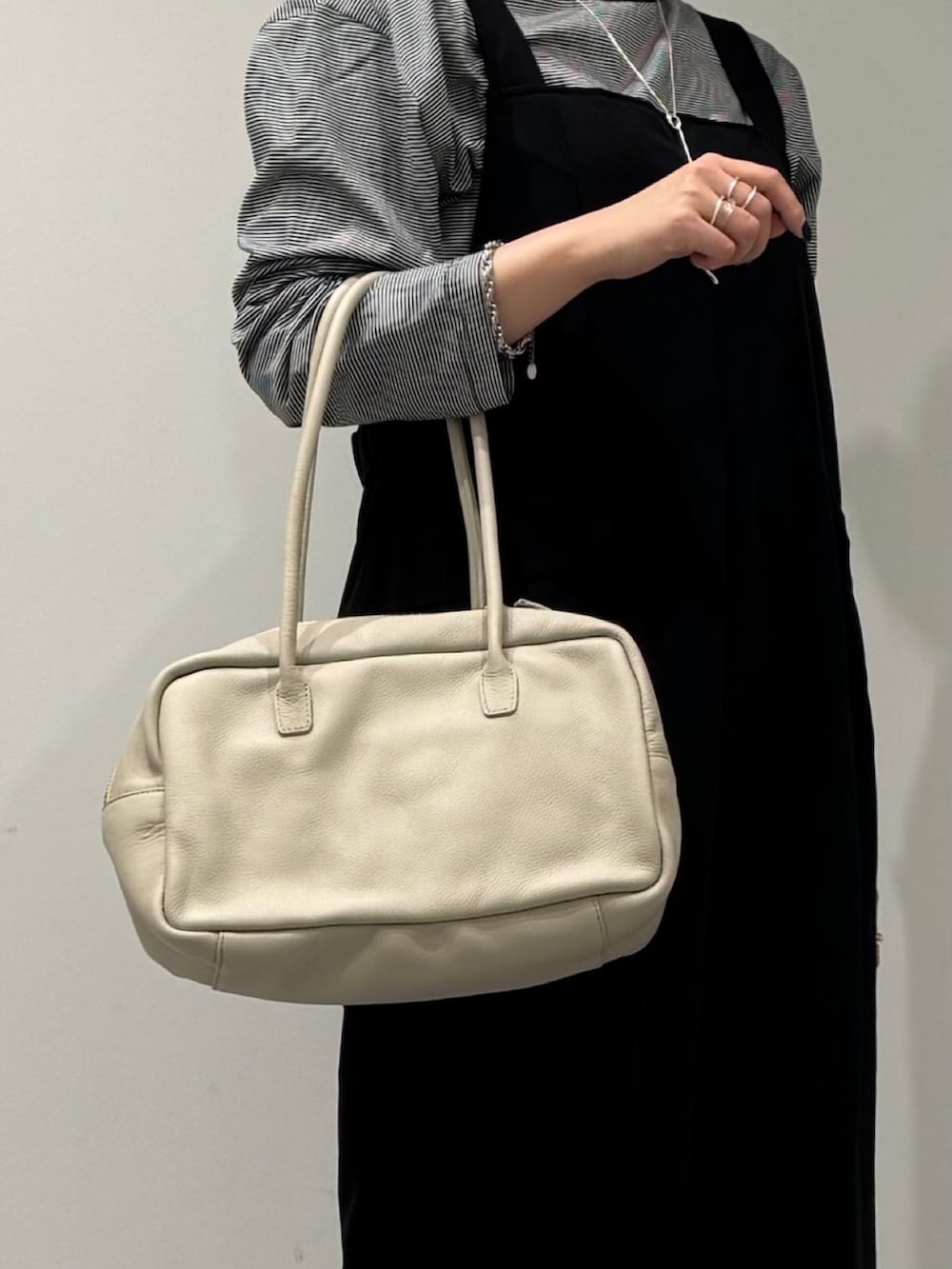 ベージュ系のボストンバッグ、ブラック系のサロペット/オーバーオール、ブラック系のローファーを着用したレディースの春コーディネートの9枚目の写真