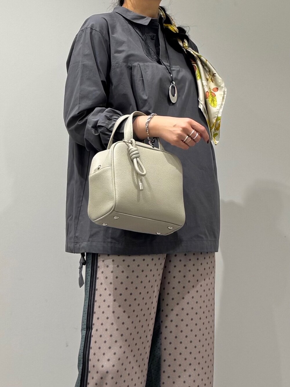 グレー系のボストンバッグ、ベージュ系のその他パンツ、ブラック系のローファーを着用したレディースの秋コーディネートの7枚目の写真