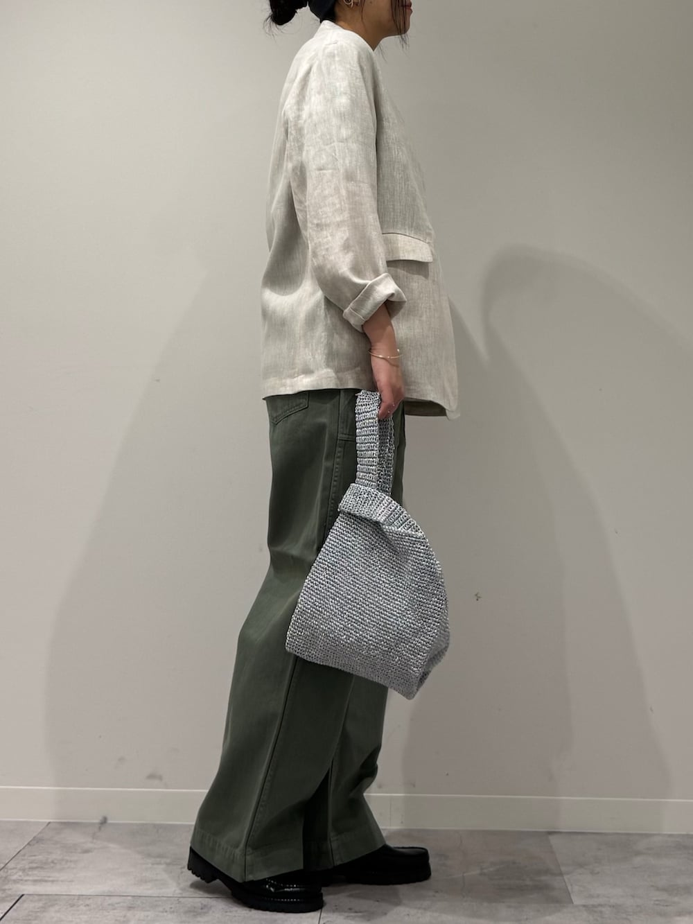 シルバー系のかごバッグ、グリーン系のその他パンツ、ブラック系のローファーを着用したレディースの春コーディネートの2枚目の写真