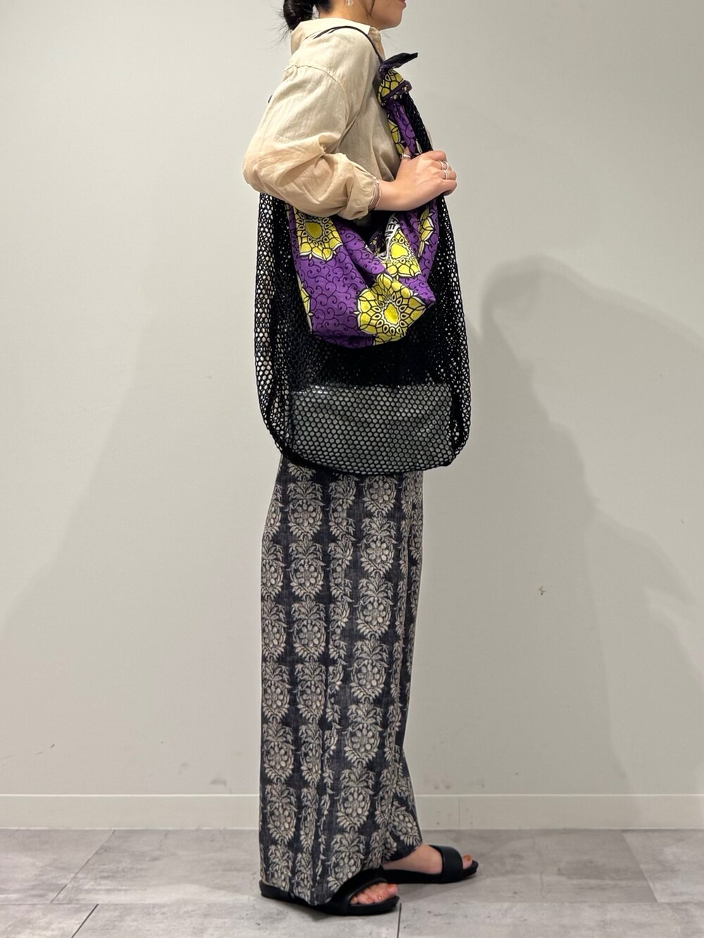 ブラック系のその他パンツ、ブラック系のサンダル、ベージュ系のシャツ/ブラウスを着用したレディースの夏コーディネートの2枚目の写真
