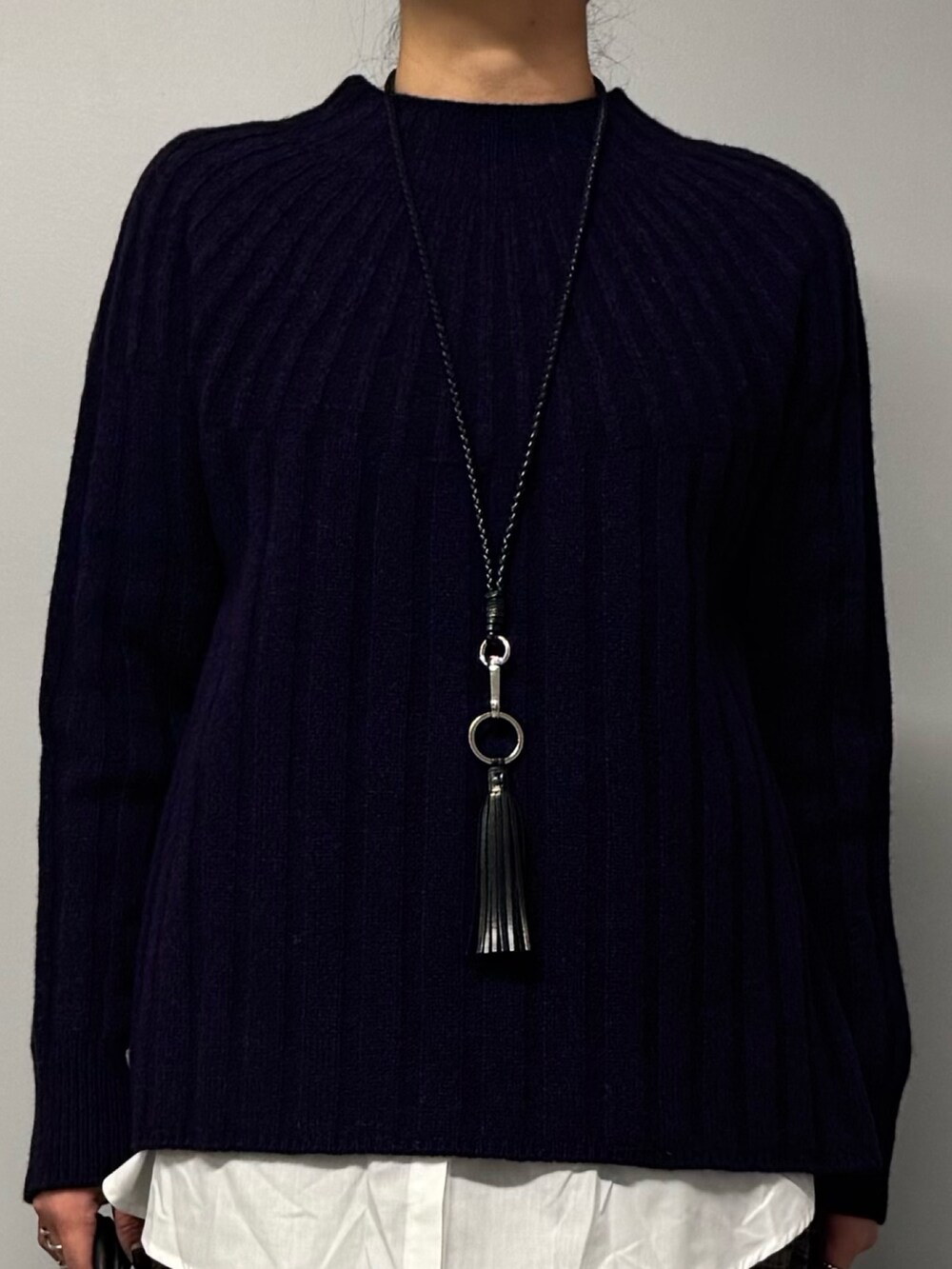 ブルー系のニット/セーター、ブラック系のトートバッグ、ブラウン系のその他パンツを着用したレディースの冬コーディネートの6枚目の写真