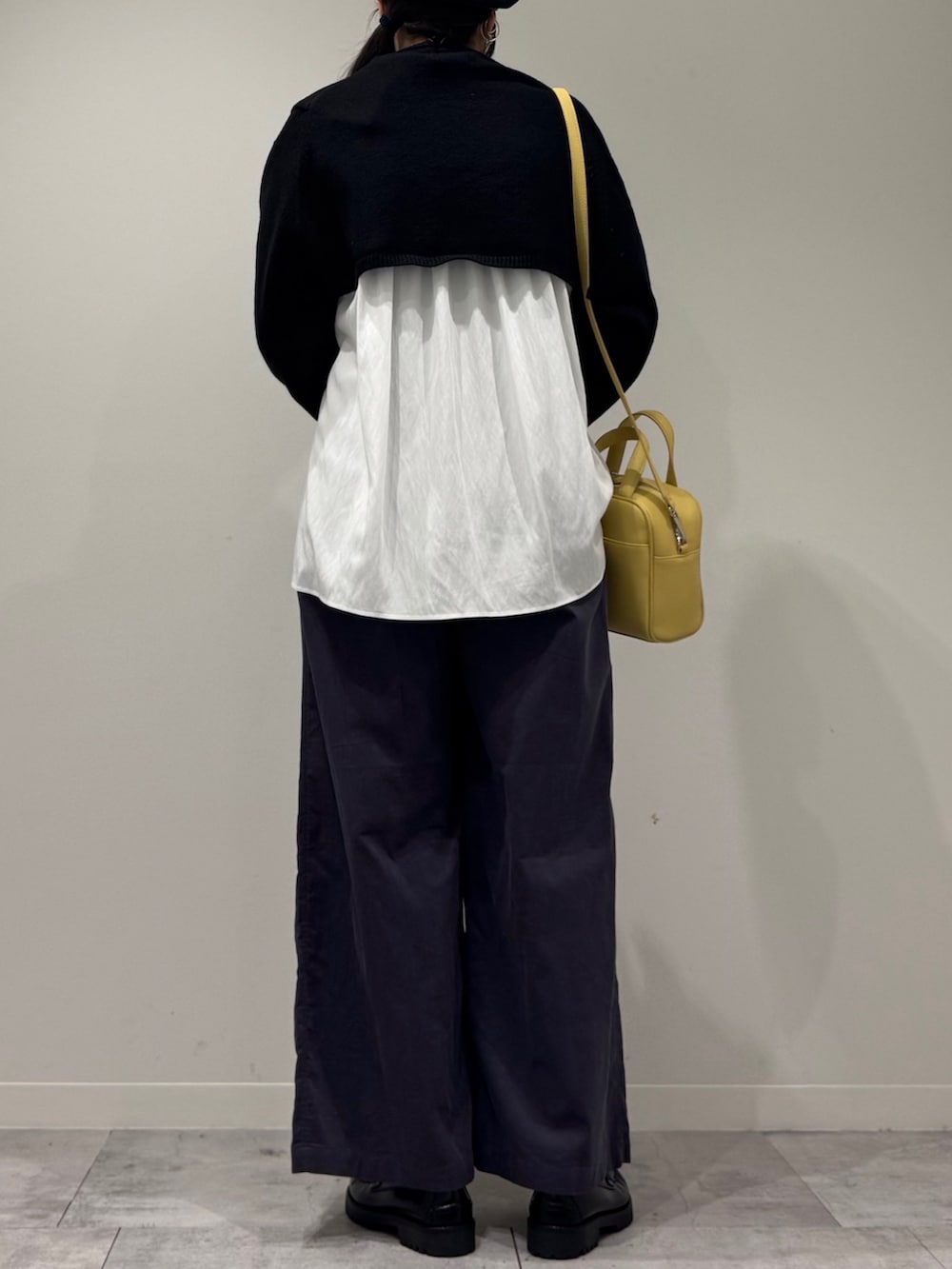 イエロー系のボストンバッグ、ブラック系のローファー、ホワイト系のシャツ/ブラウスを着用したレディースの冬コーディネートの3枚目の写真