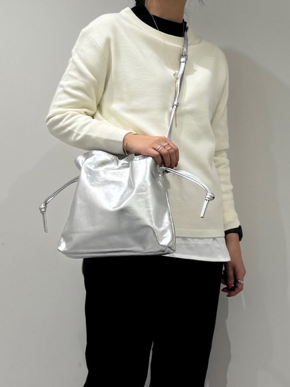 ブラック系のその他パンツ、ブラック系のローファー、シルバー系のショルダーバッグを着用したレディースの春コーディネートの7枚目の写真